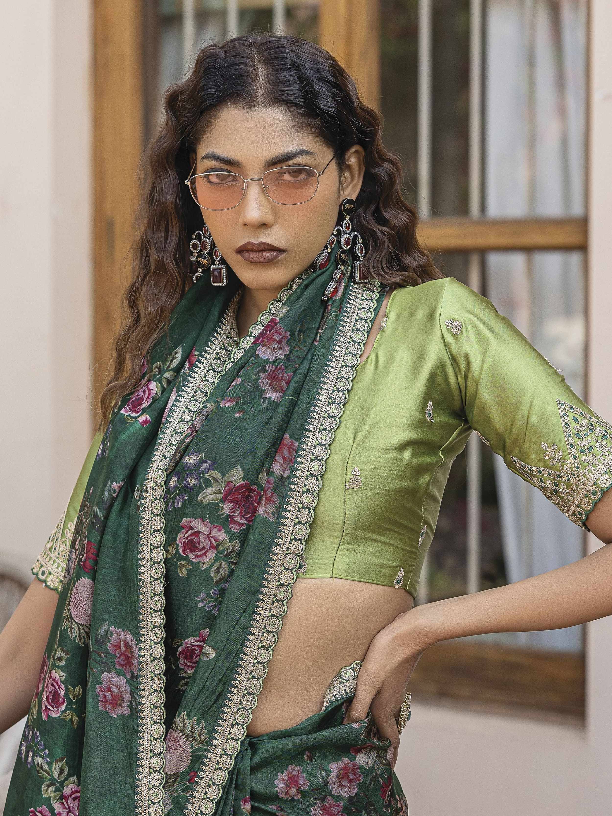 Green floral saree with embroidered border and matching blouse, styled with statement earrings and sunglasses