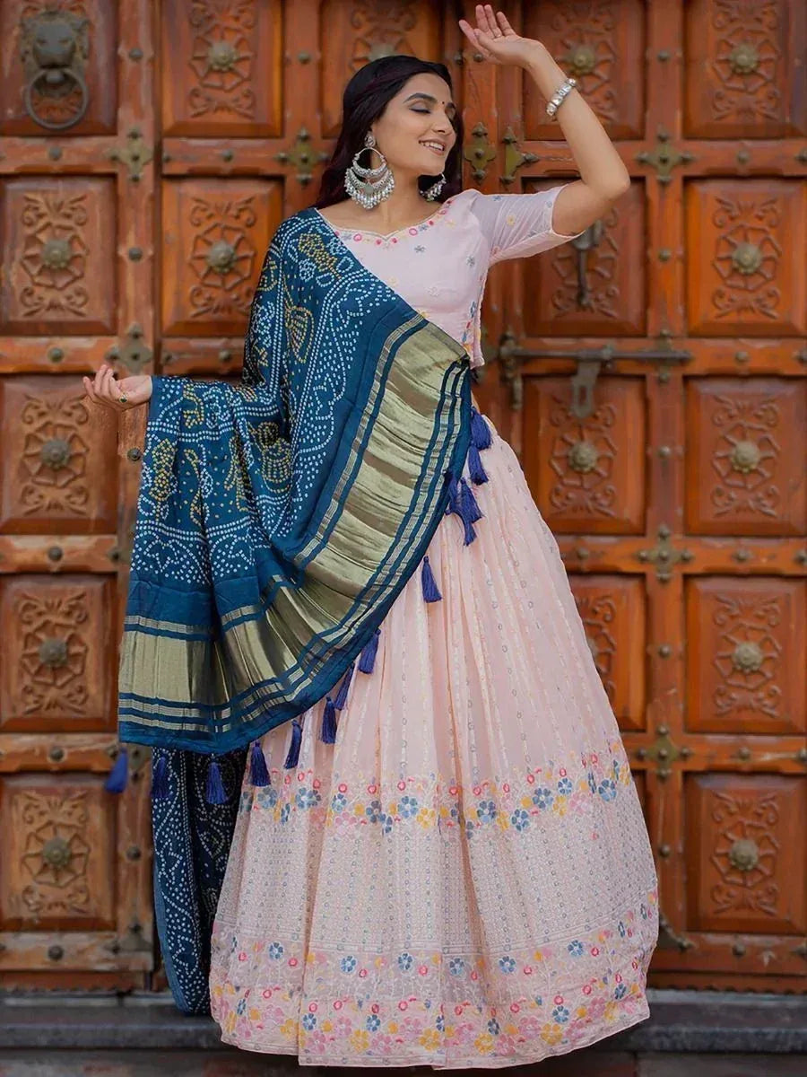 Woman in pink floral lehenga choli with blue bandhani dupatta, traditional Indian ethnic wear