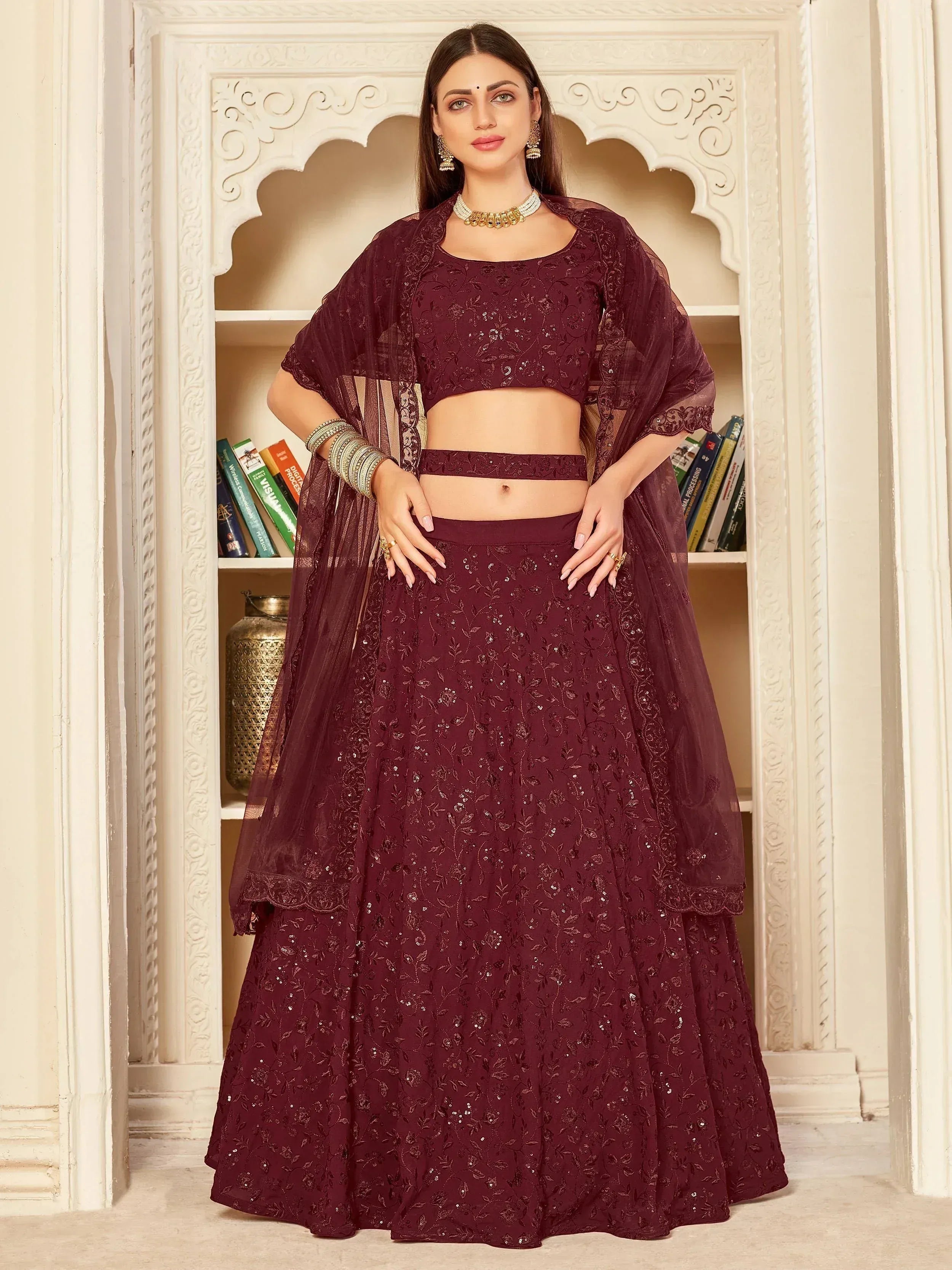 Elegant maroon lehenga choli with intricate embroidery and sheer dupatta, perfect for Indian ethnic occasions.
