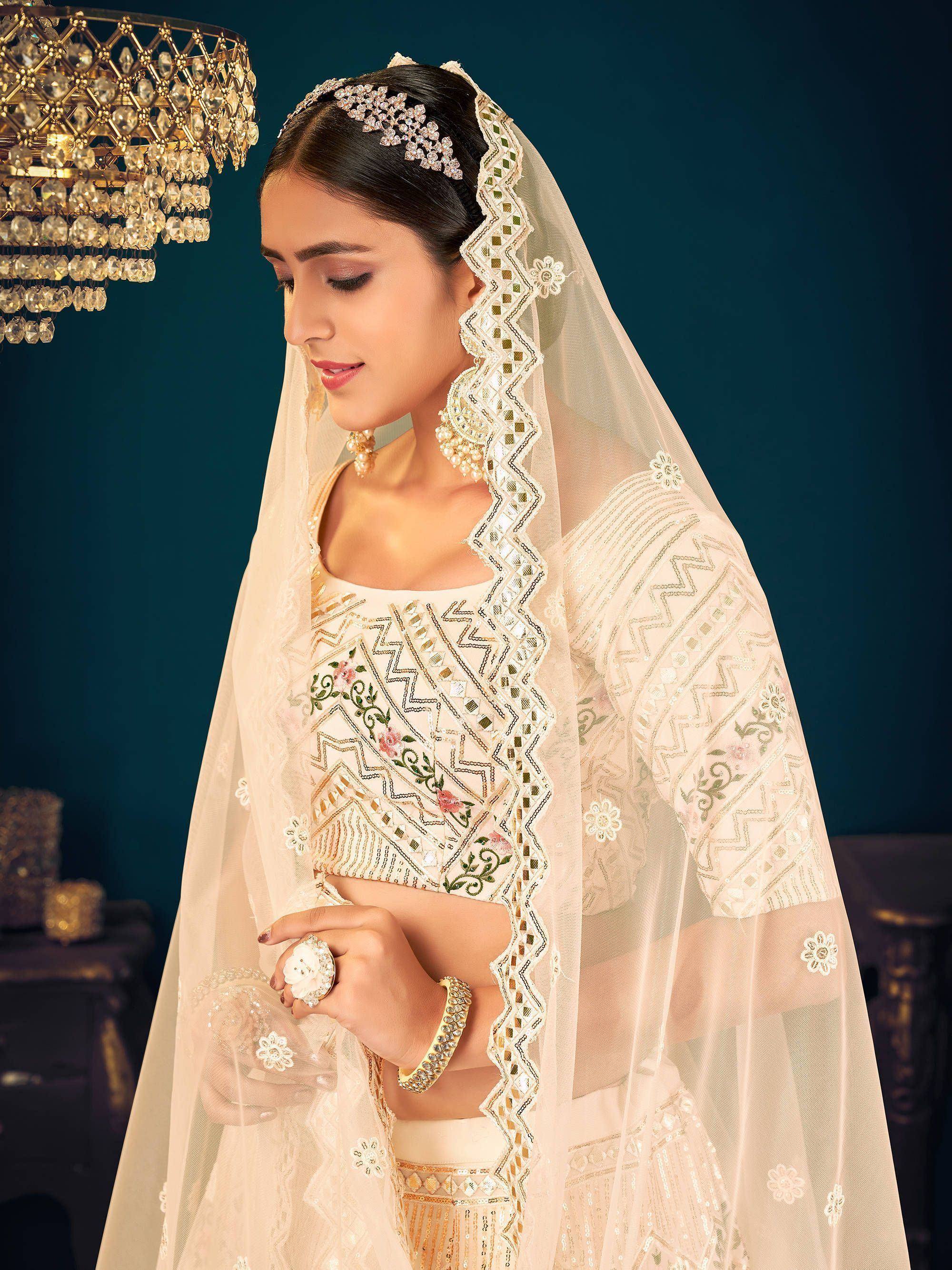 Elegant ivory bridal lehenga choli with floral embroidery, mirror work, and sheer dupatta for Indian weddings