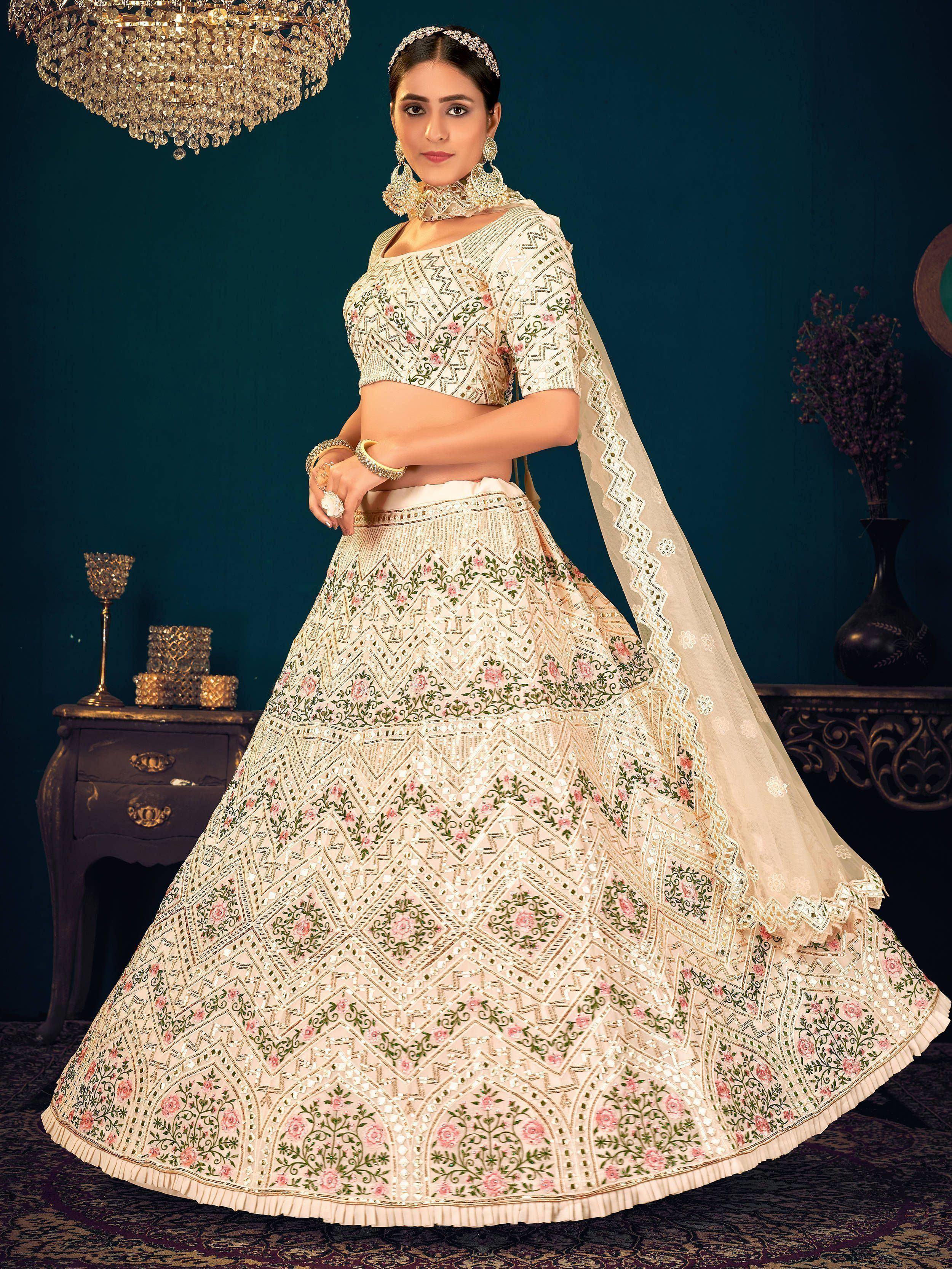Elegant ivory lehenga choli with floral embroidery and mirror work, perfect for Indian weddings and festive occasions.