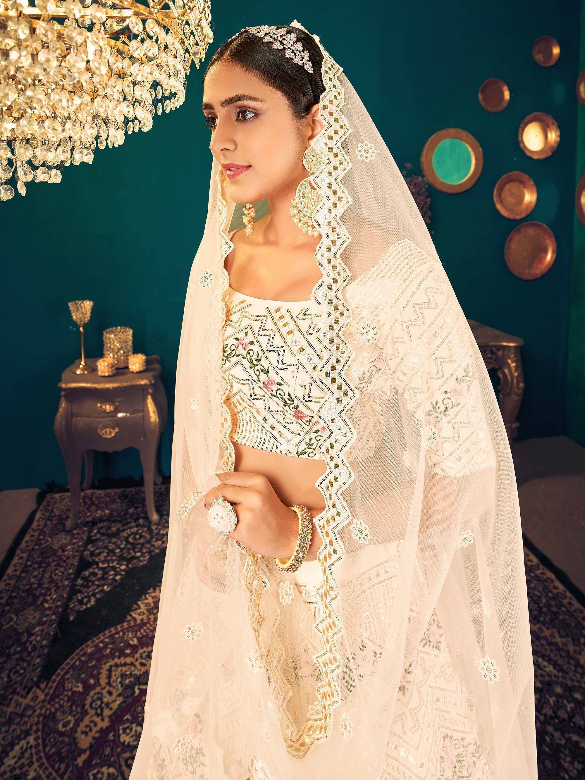 Elegant white embroidered lehenga choli with dupatta, perfect for Indian weddings and festive occasions.