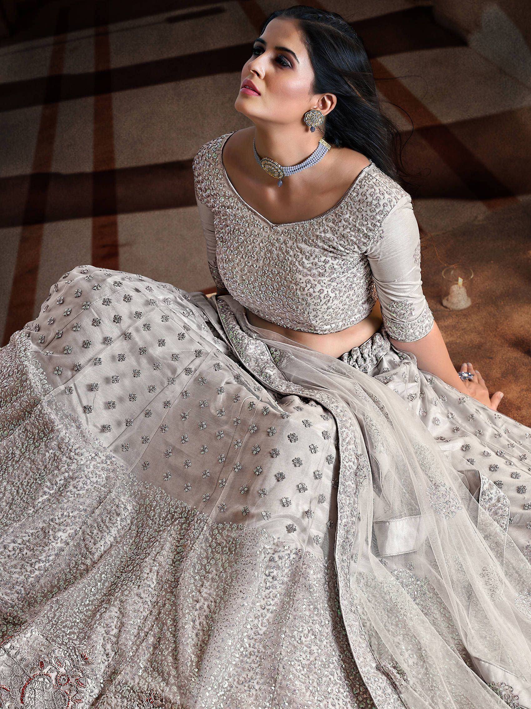 Elegant silver embroidered lehenga choli with floral motifs, perfect for Indian weddings and festive occasions.