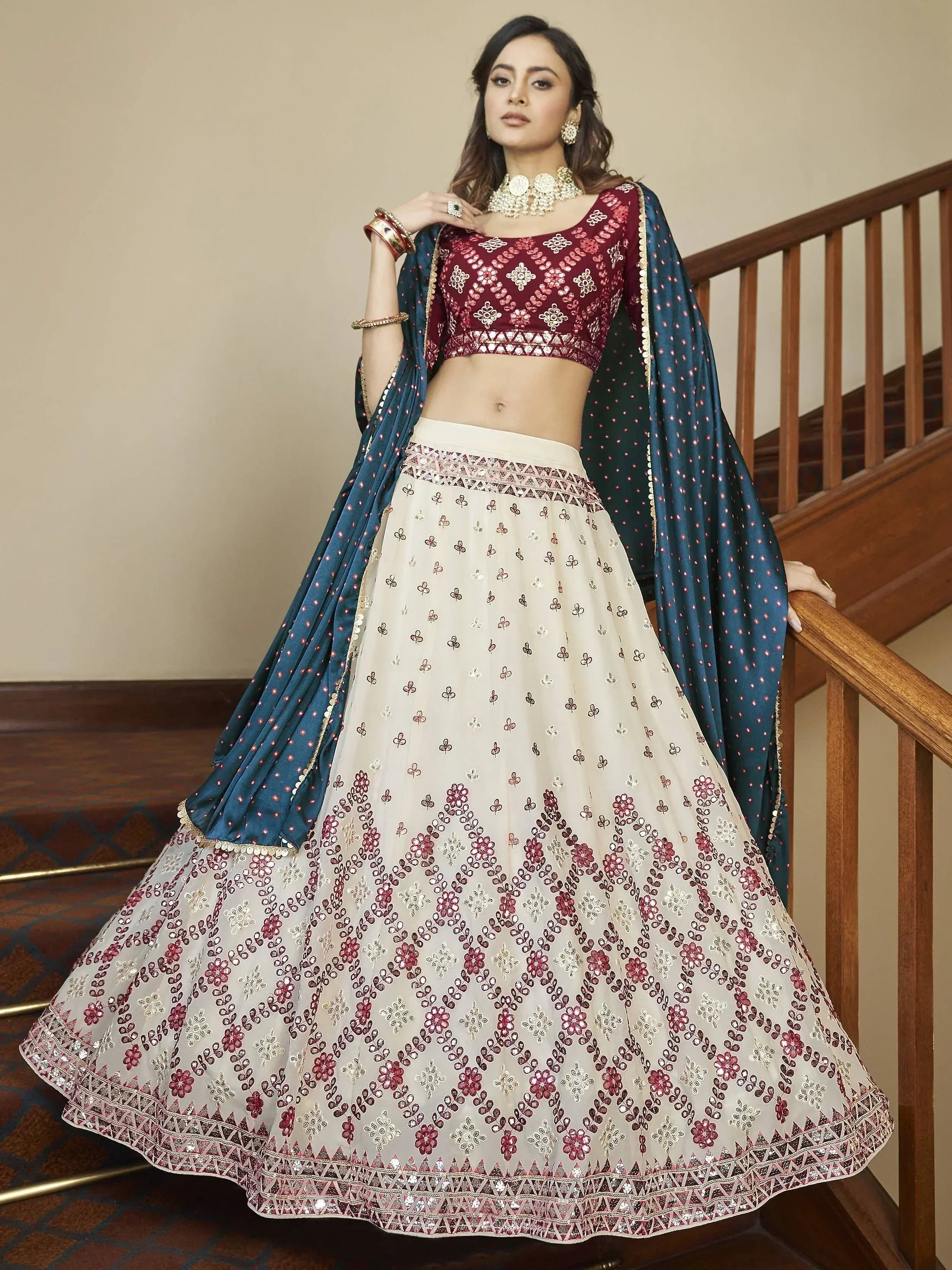 Elegant maroon and cream embroidered lehenga choli with teal dupatta, perfect for Indian weddings and festive occasions.