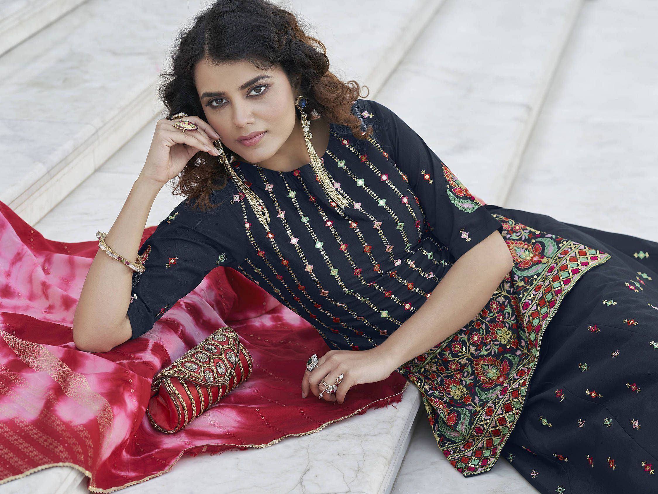 Woman in black embroidered salwar kameez with red dupatta, ethnic Indian wear