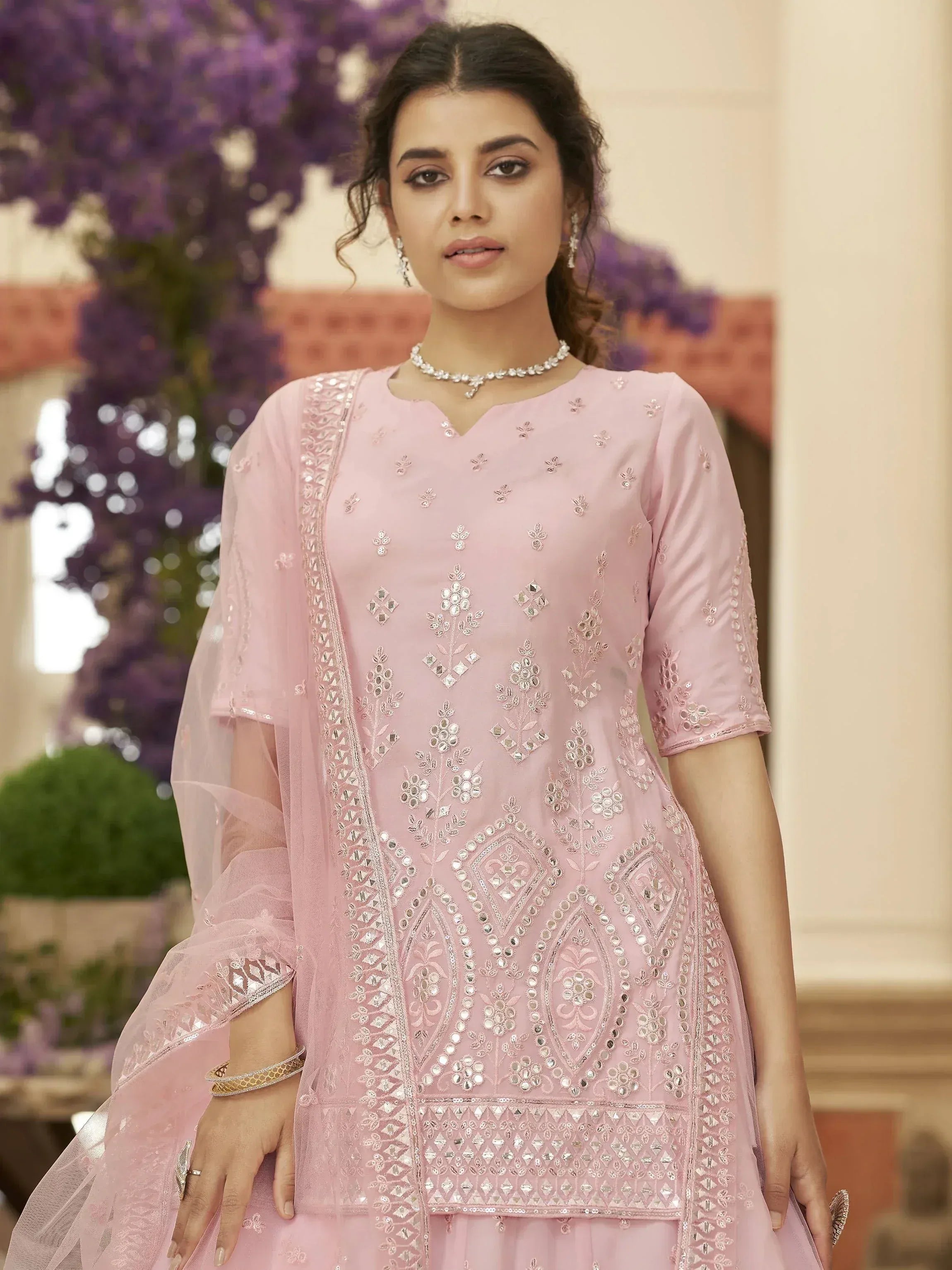 Pink embroidered ethnic gown with mirror work and sheer sleeves, perfect for Indian festive occasions