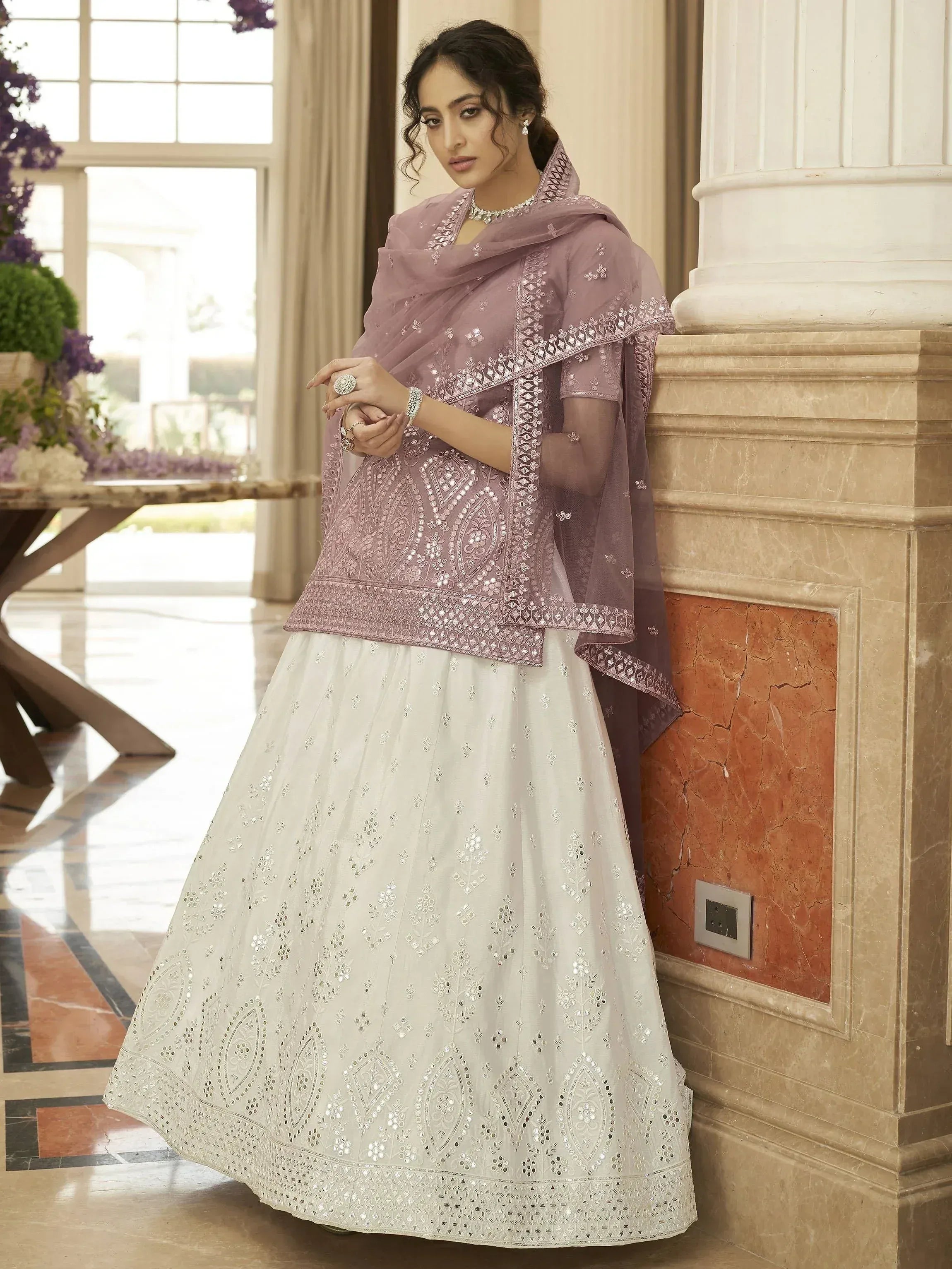 Elegant Indian ethnic wear: mauve embroidered top with white lehenga and dupatta, perfect for weddings or festive occasions.