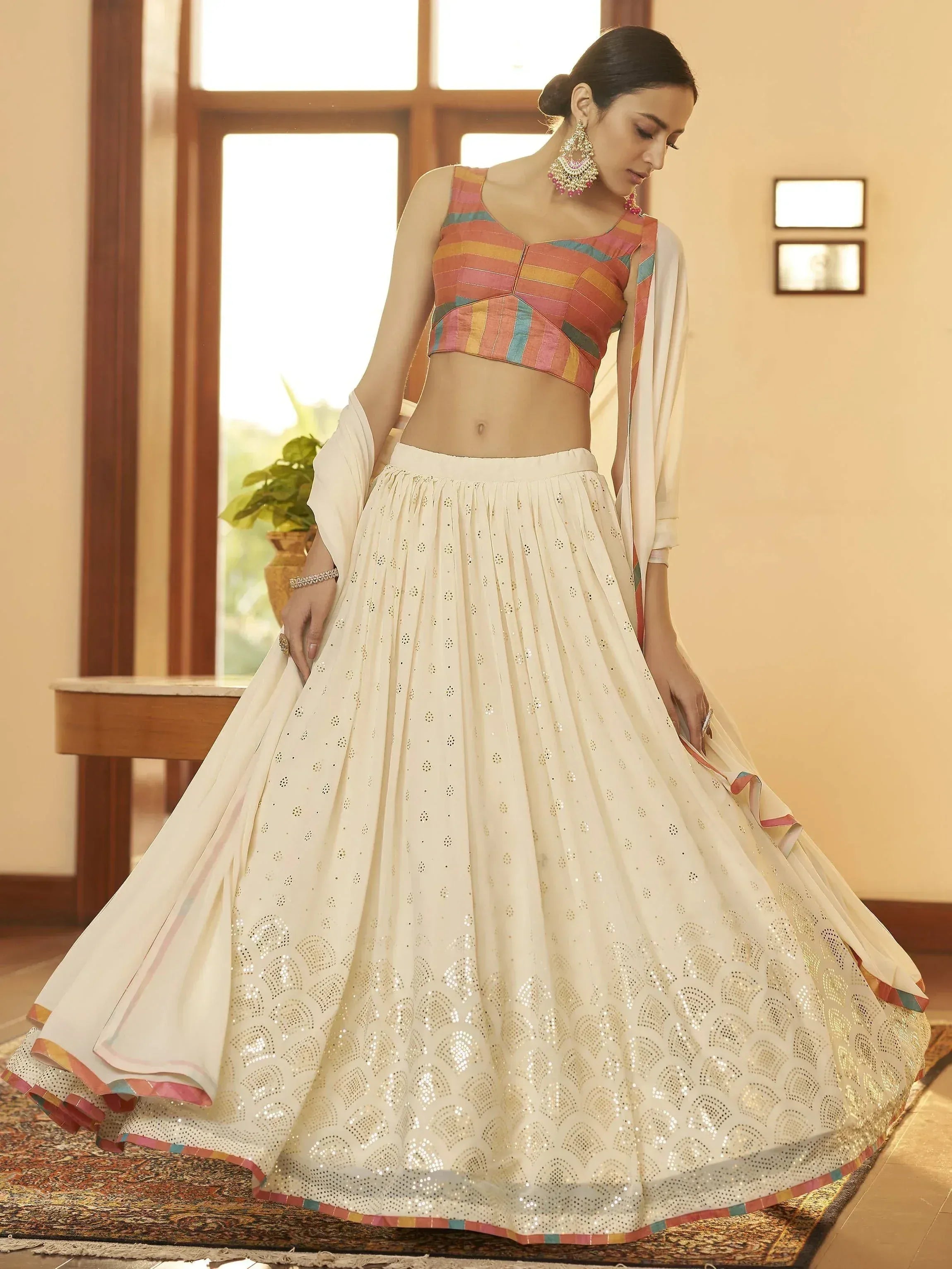 Woman in ivory lehenga with sequin work and colorful striped blouse, ethnic Indian wear