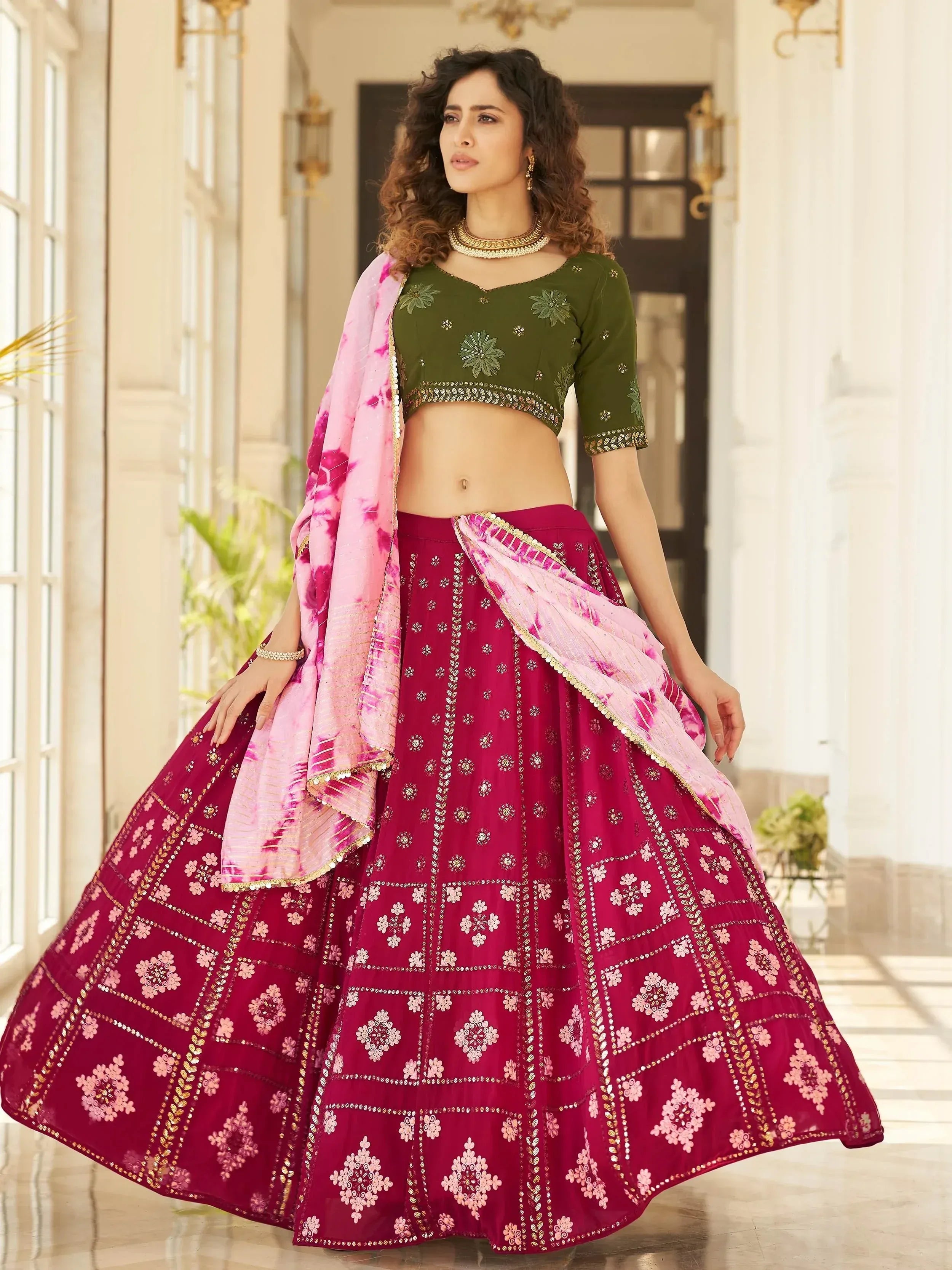 Woman in maroon lehenga choli with green blouse and pink dupatta, Indian ethnic wear