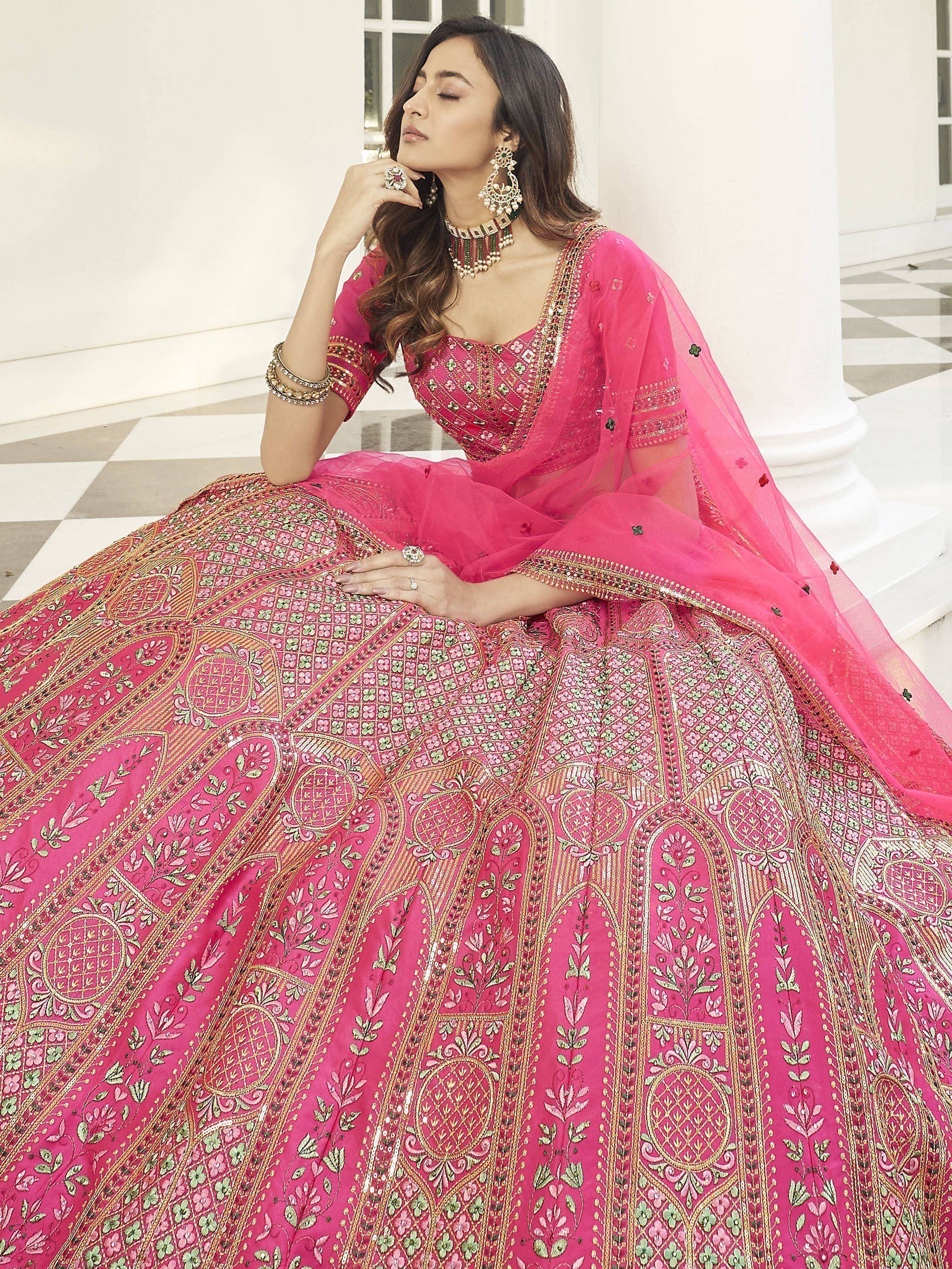 Pink embroidered lehenga choli with gold floral patterns, perfect for Indian weddings and festive occasions.