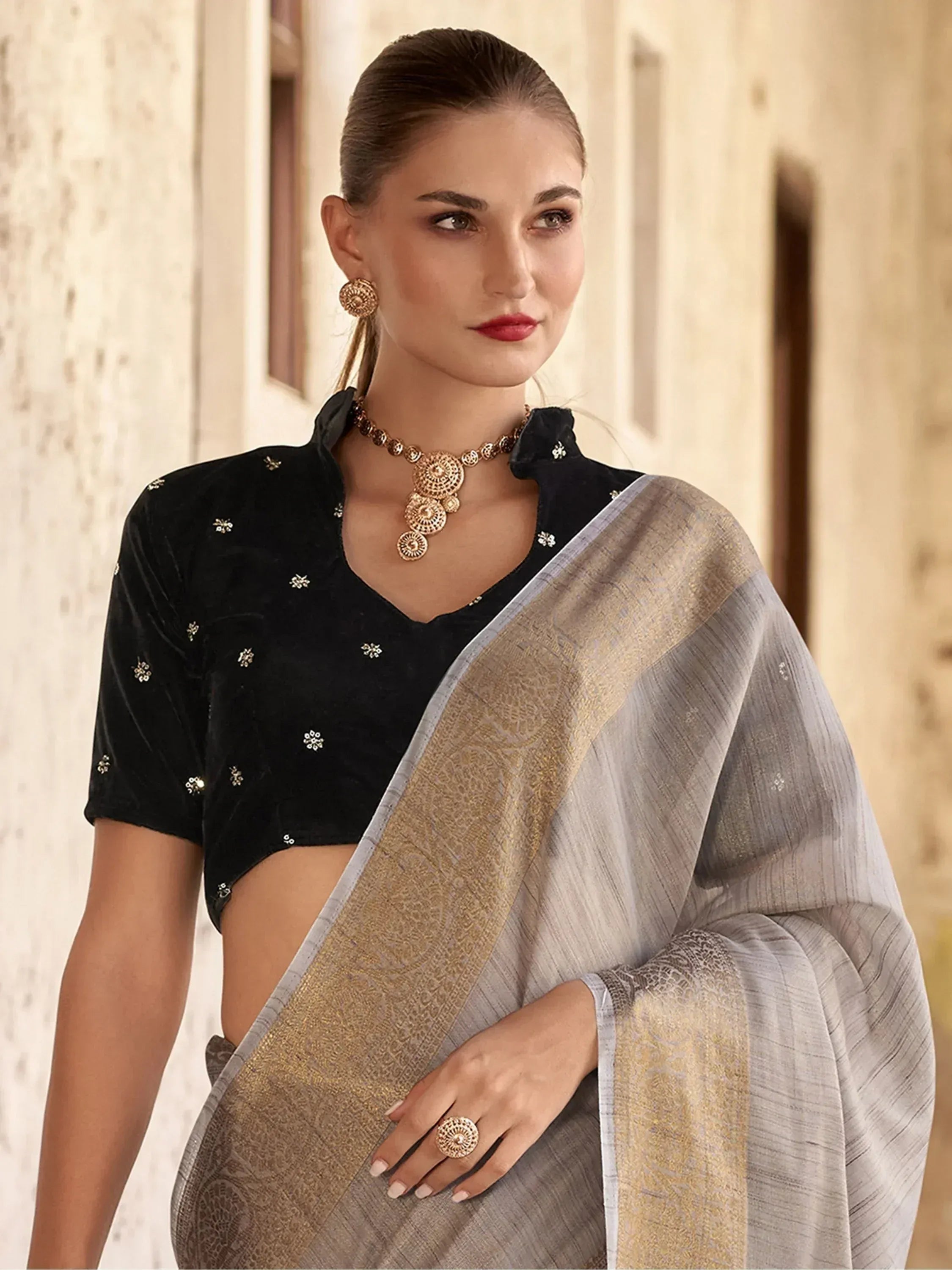 Elegant grey saree with gold border paired with black velvet blouse, perfect for Indian ethnic wear occasions.