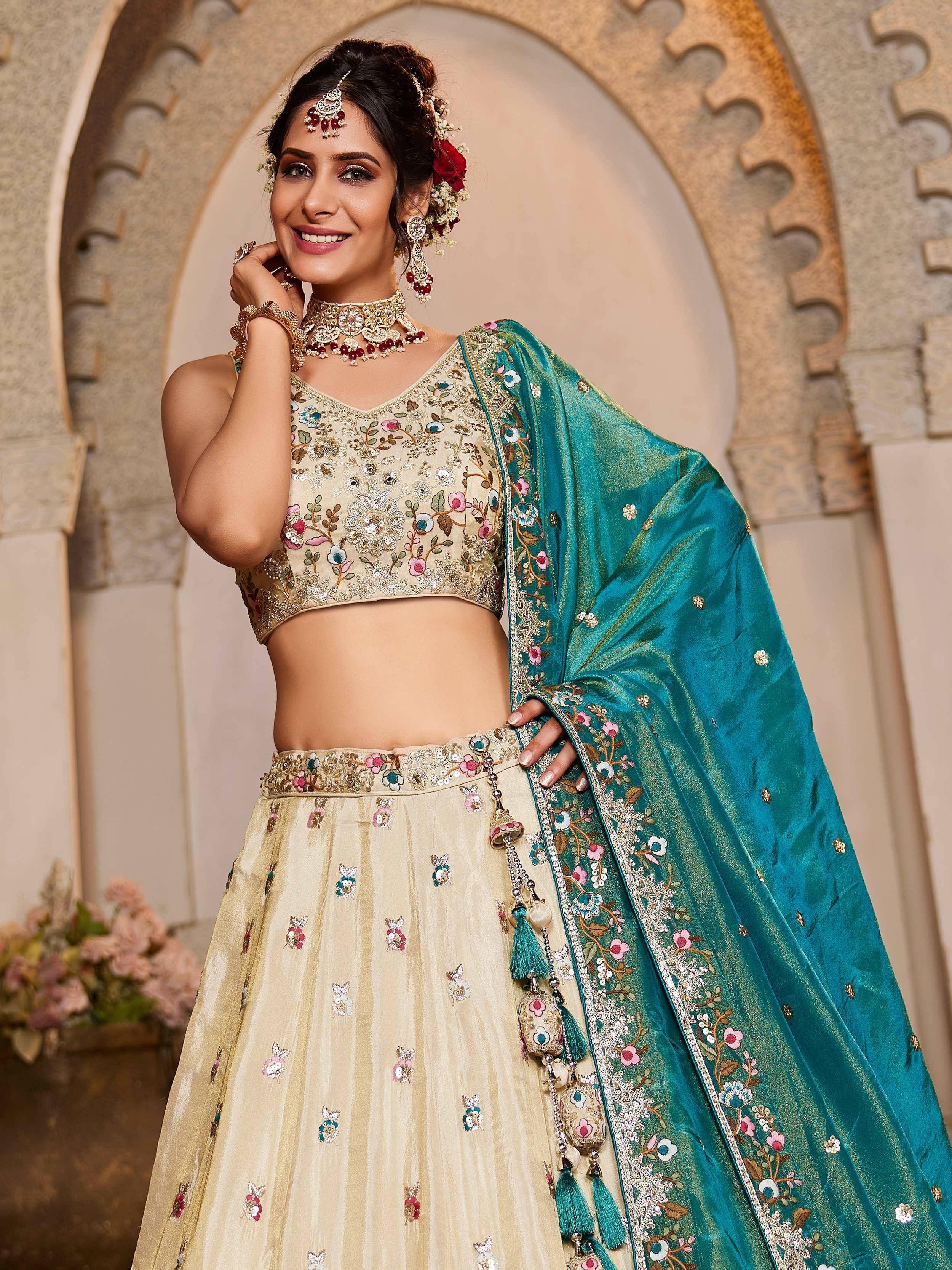 Elegant beige lehenga choli with teal dupatta, floral embroidery, and tassels for Indian ethnic wear