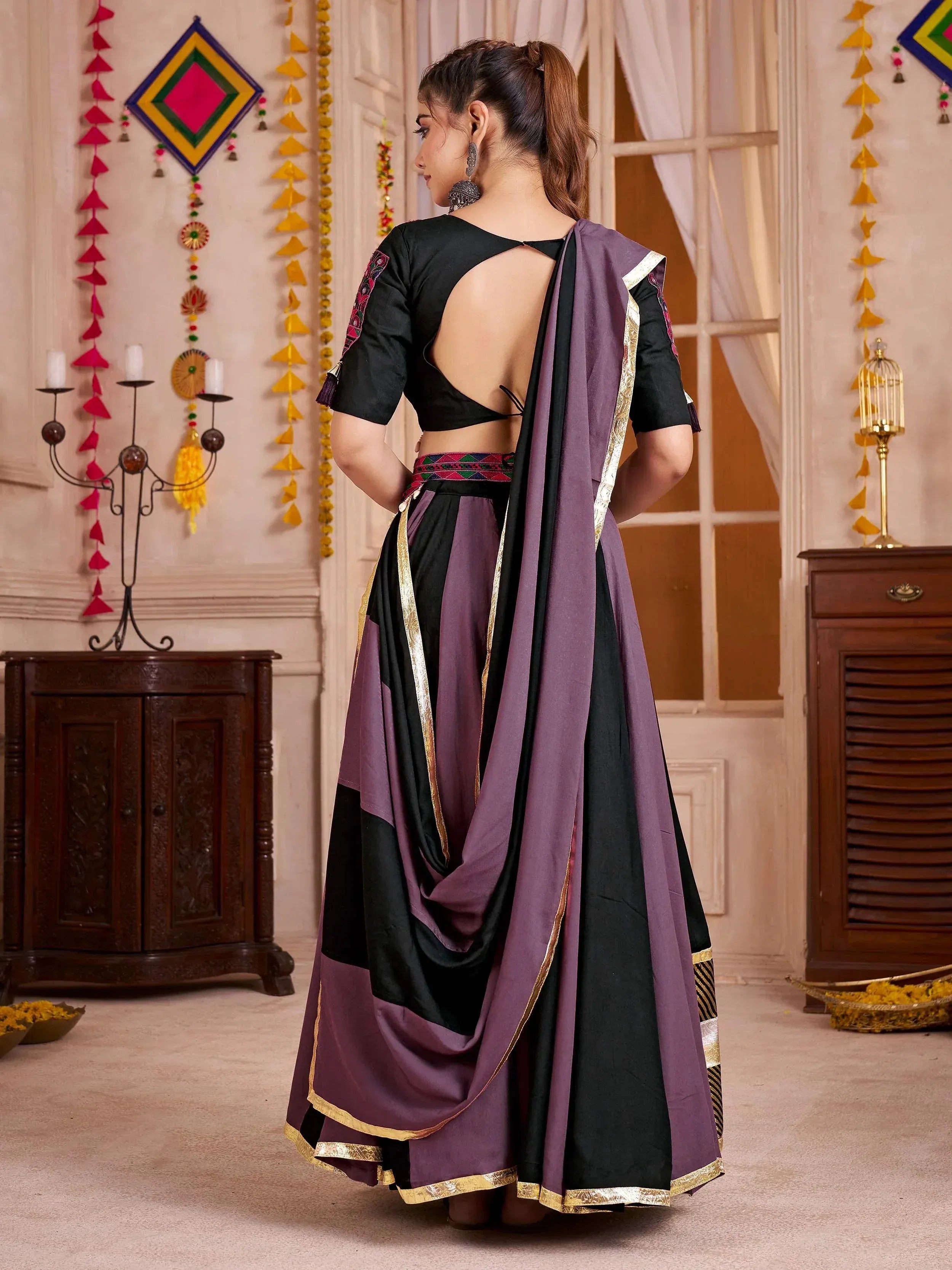 Purple and black ethnic saree with gold trim and open back blouse