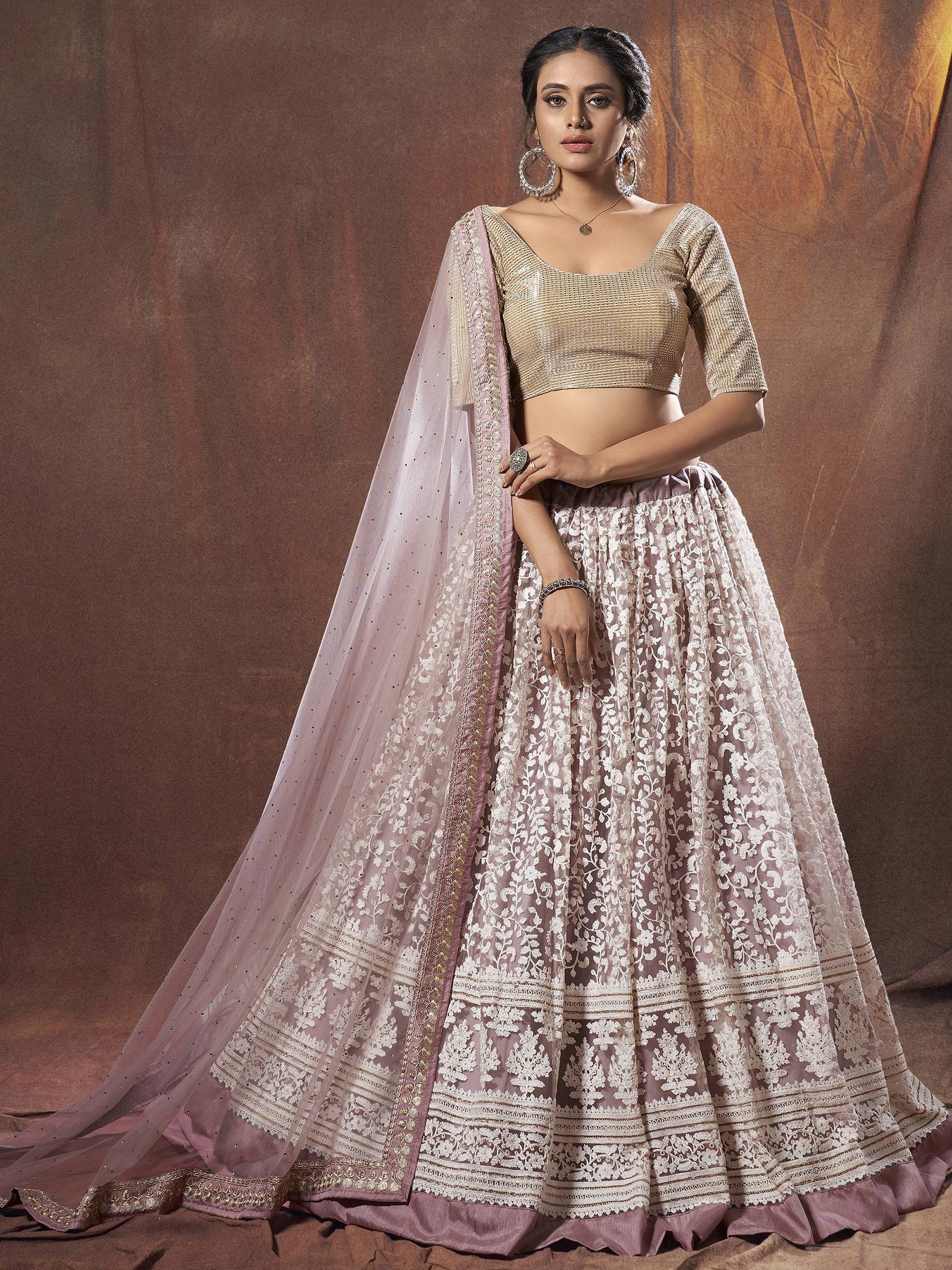 Elegant mauve lehenga choli with gold embroidery and sheer dupatta, perfect for Indian weddings and festive occasions.