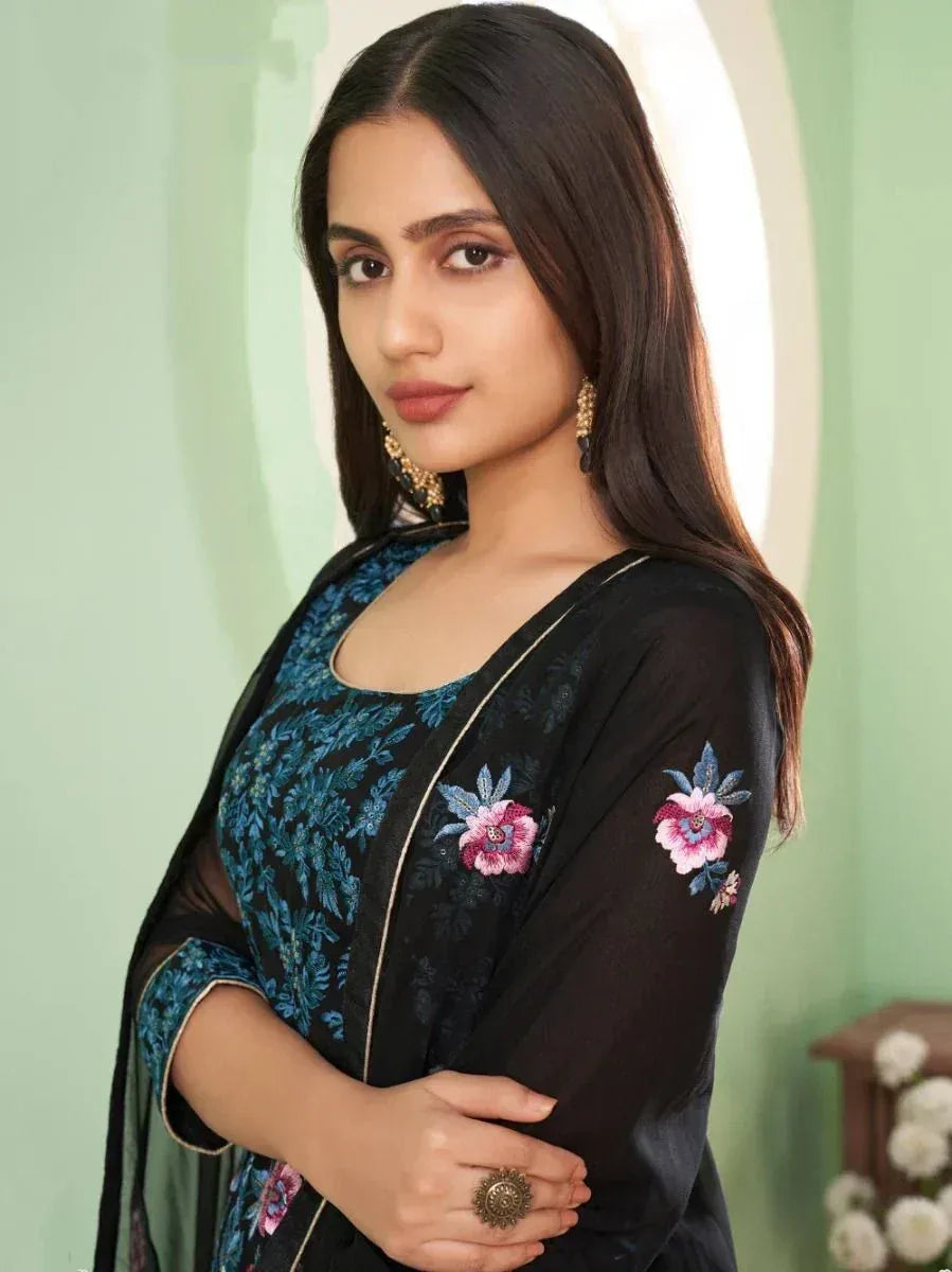 Woman in a black floral embroidered ethnic gown with blue and pink details