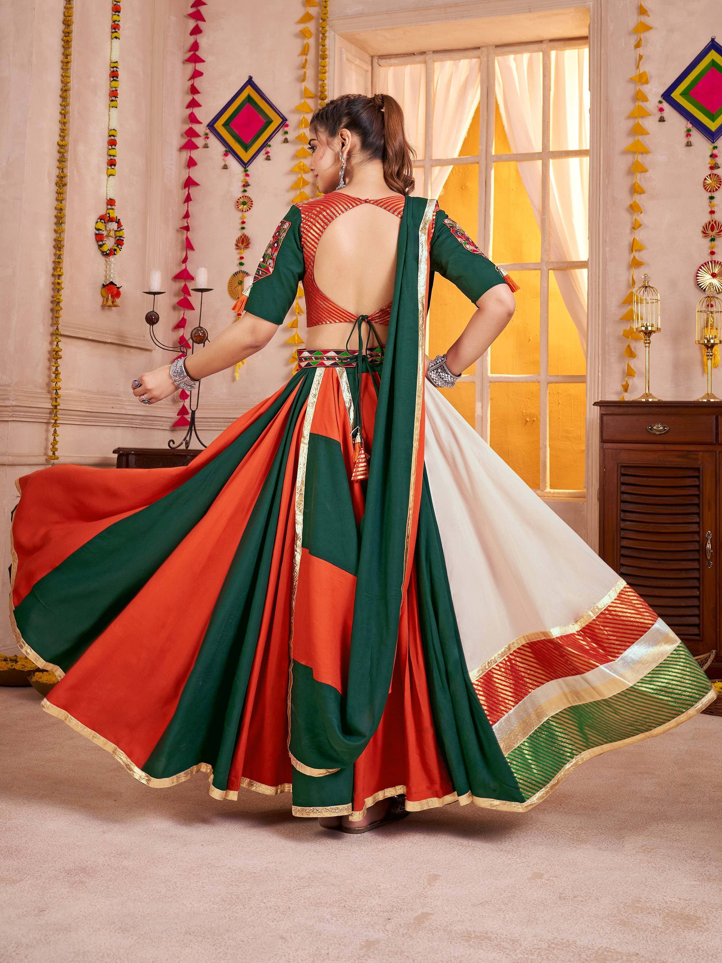Woman in vibrant green and orange lehenga choli with backless blouse, festive Indian ethnic wear