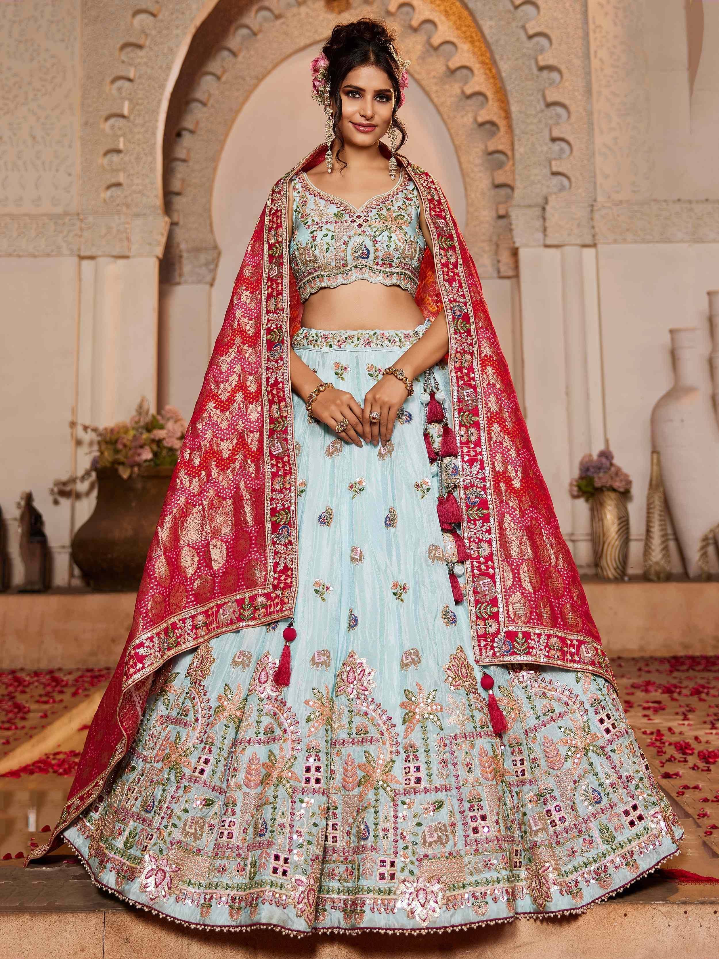 Elegant light blue lehenga choli with intricate embroidery and red dupatta, perfect for Indian ethnic occasions.