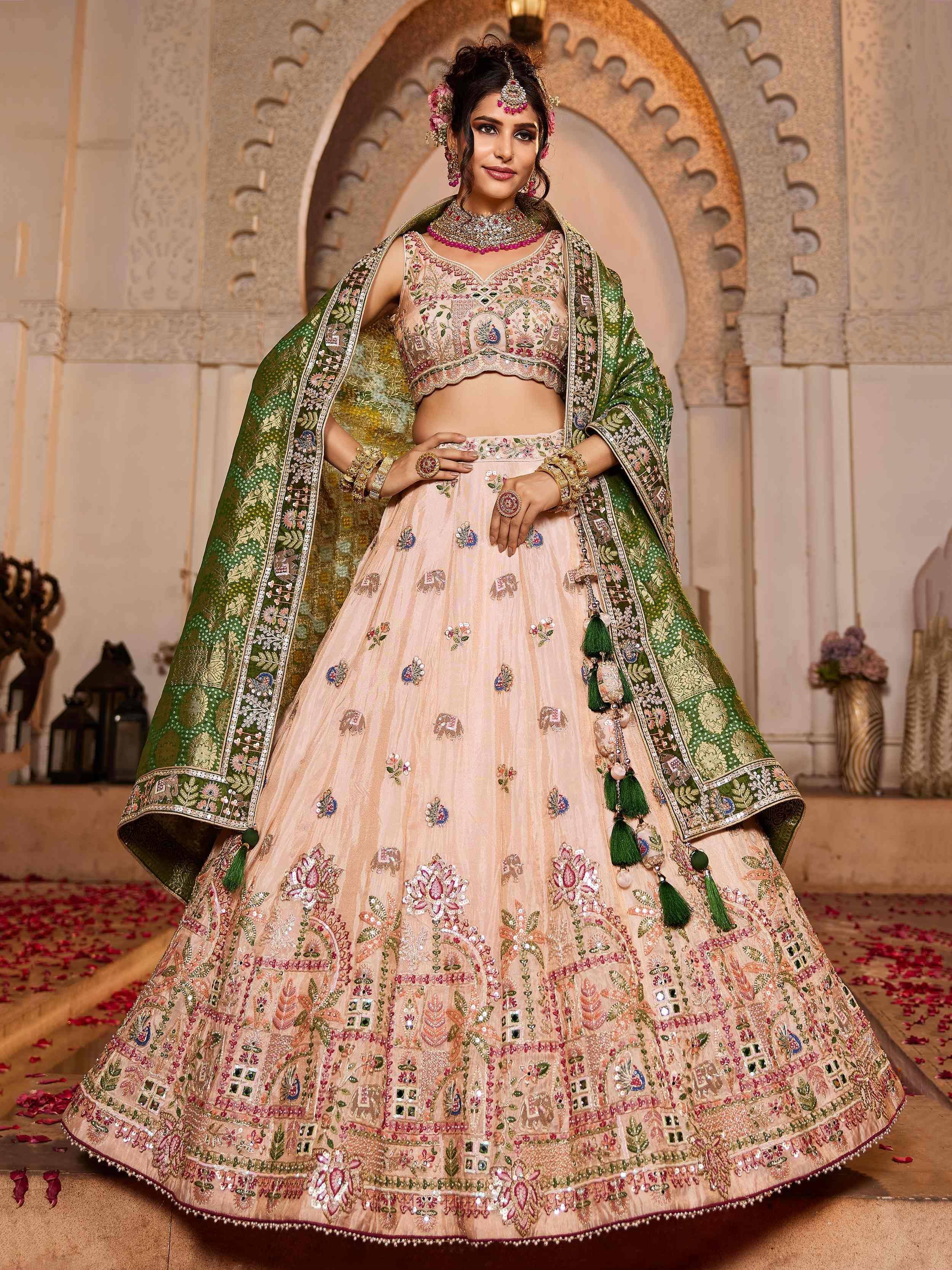 Elegant peach lehenga choli with green dupatta, heavy embroidery, perfect for Indian weddings and festive occasions.
