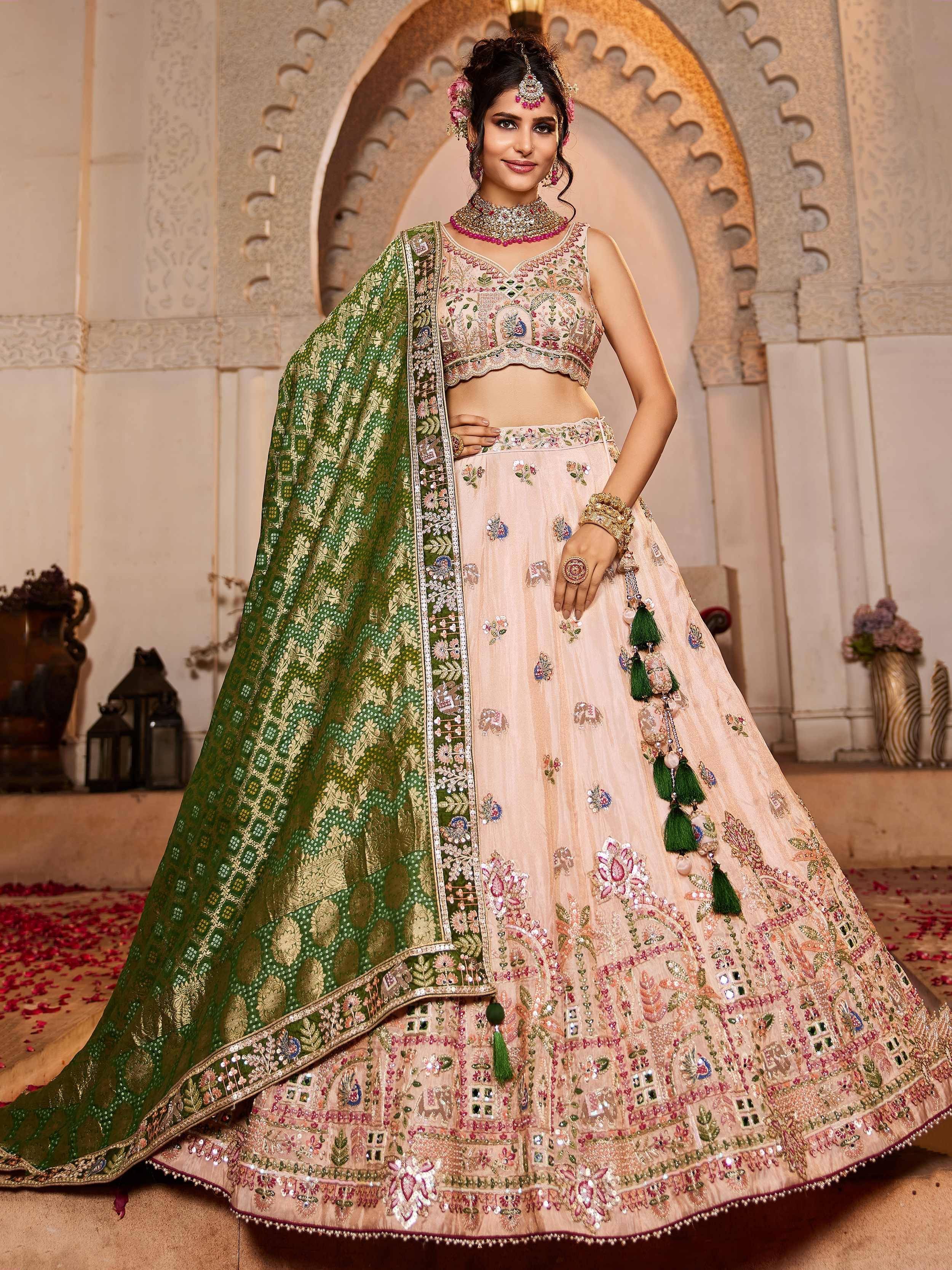 Elegant peach lehenga choli with green dupatta, floral embroidery, and tassels for Indian weddings