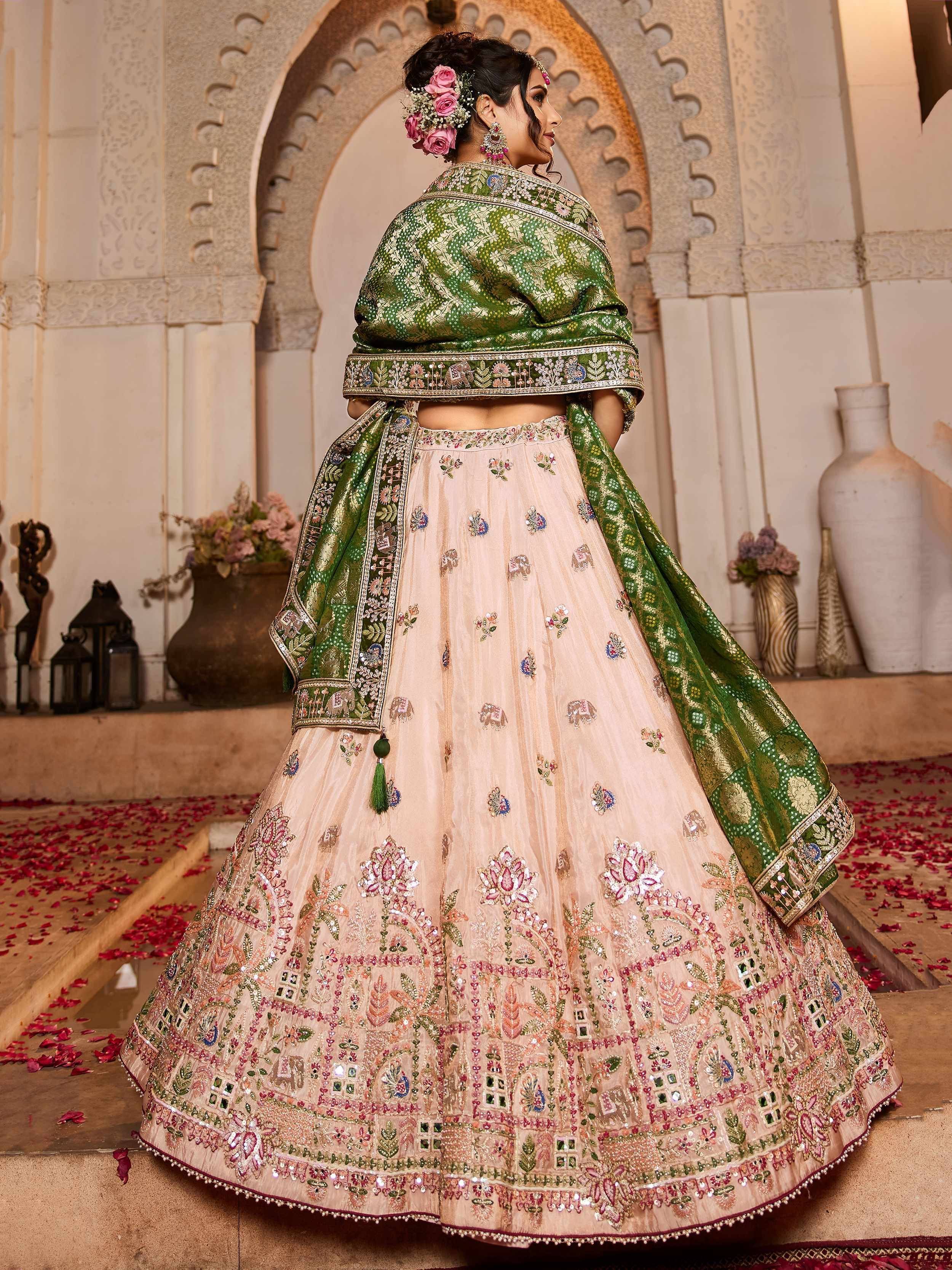 Elegant peach lehenga with intricate floral embroidery and green dupatta, perfect for Indian weddings and festive occasions.