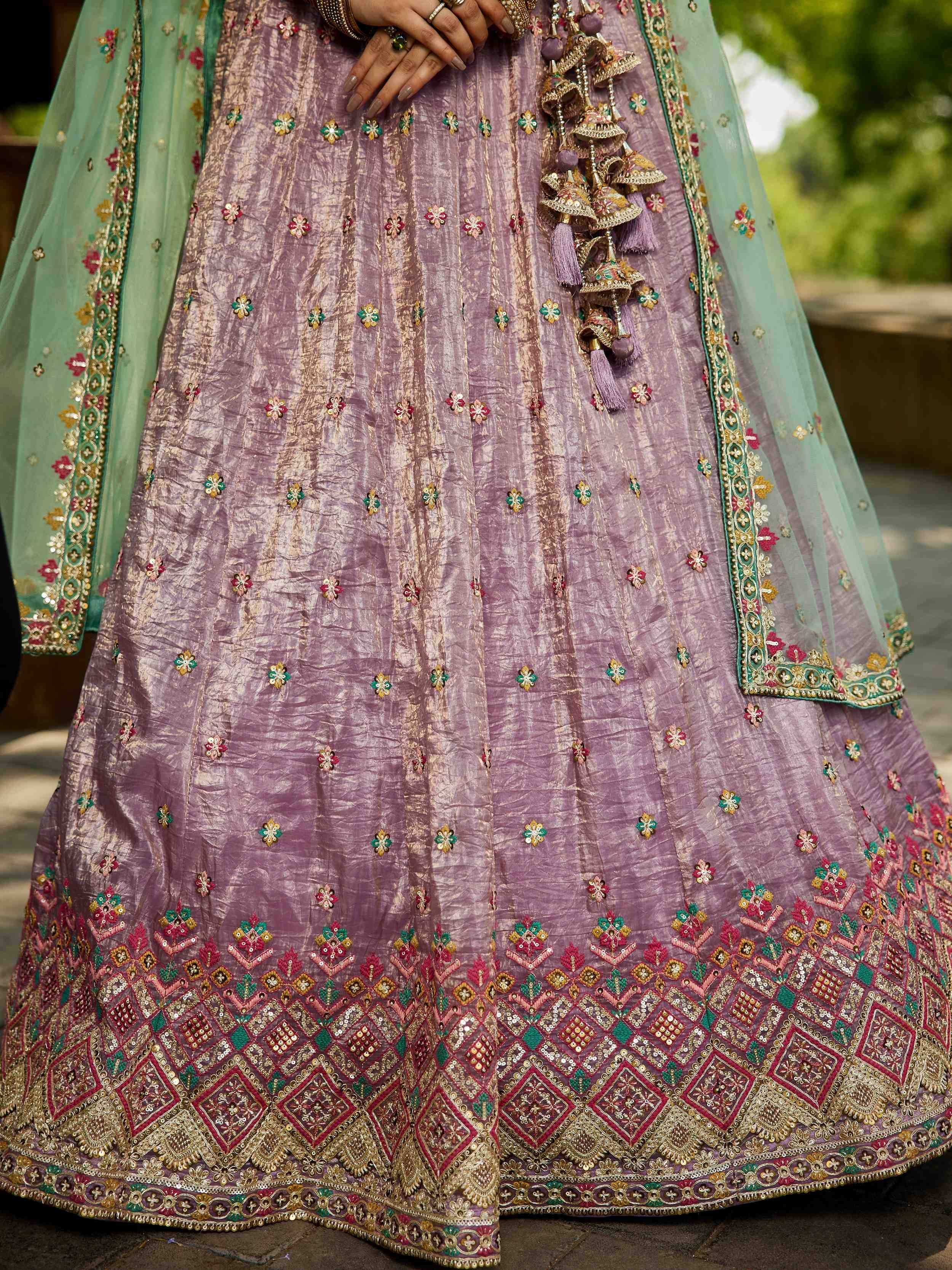 Lavender lehenga choli with intricate floral embroidery, colorful border, and sheer mint dupatta for Indian ethnic wear.