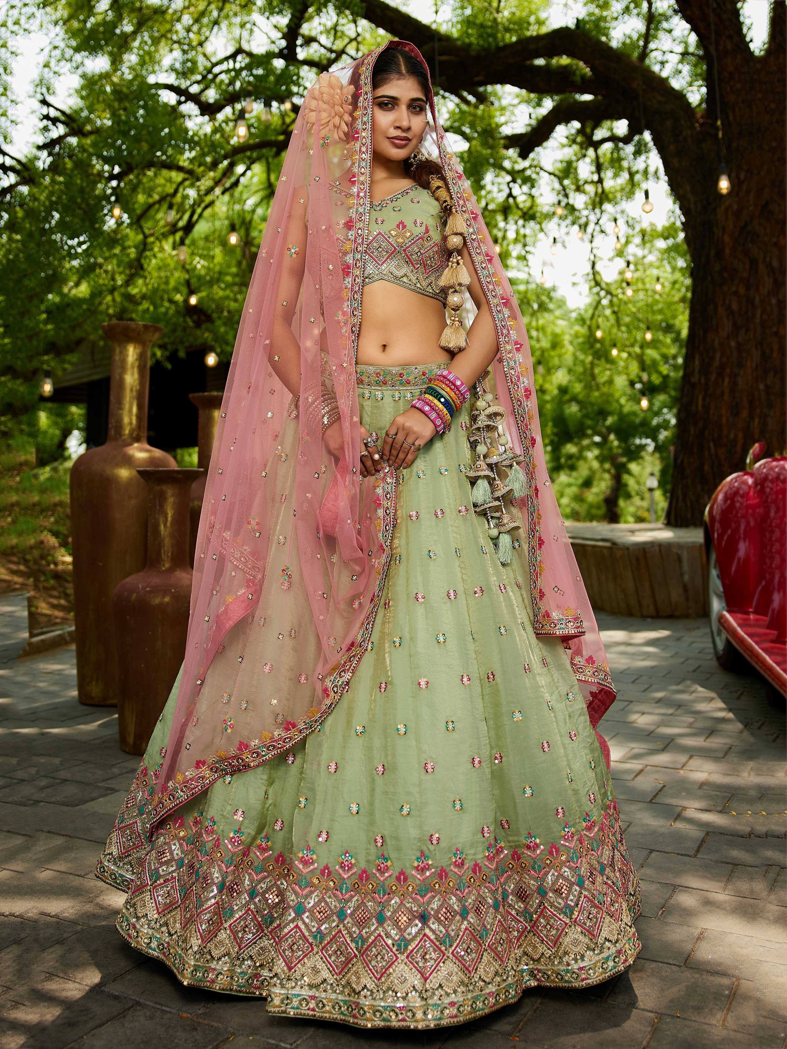 Mint green embroidered lehenga choli with pink dupatta, perfect for Indian weddings and festive occasions.