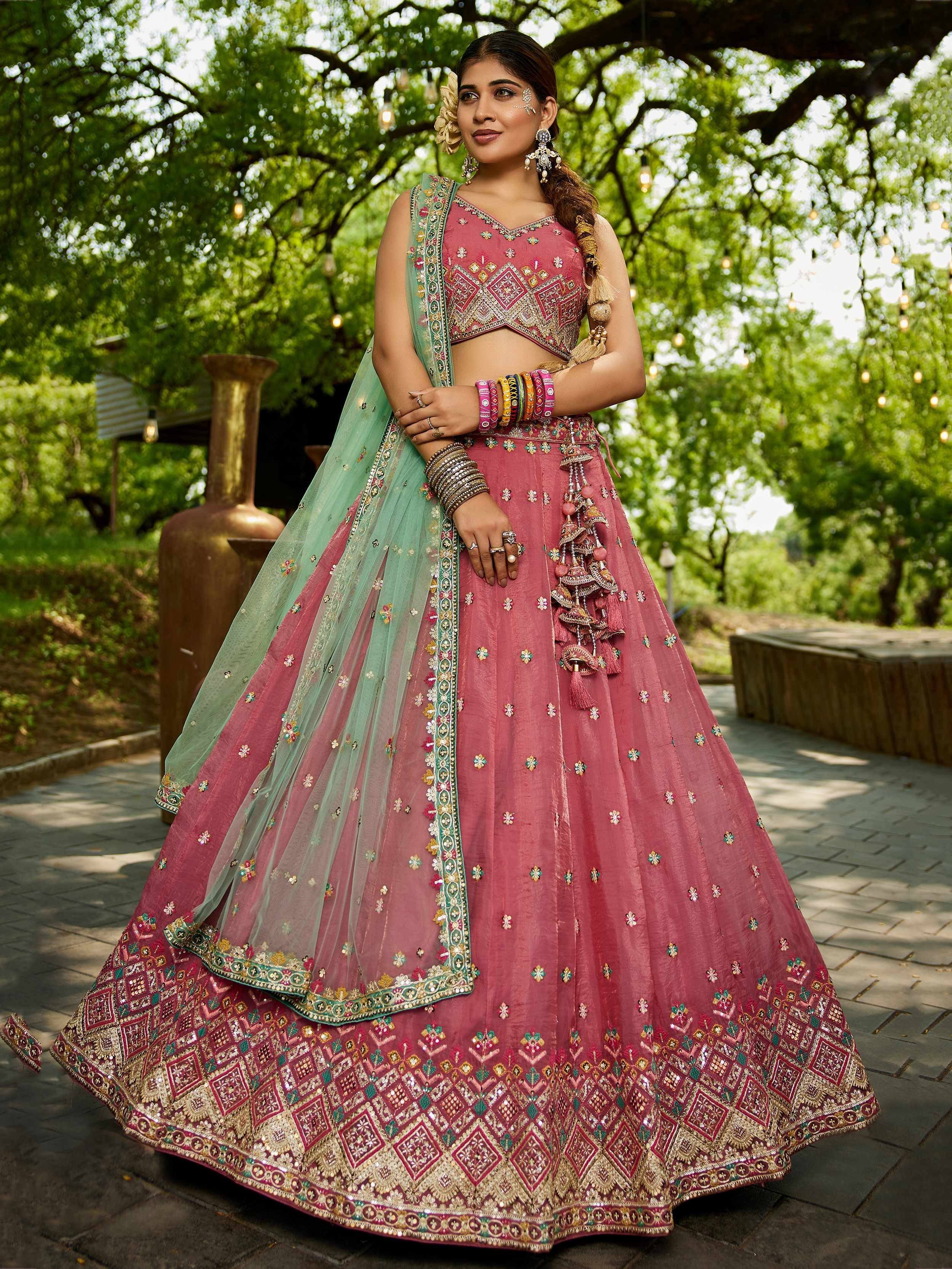 Pink embroidered lehenga choli with green dupatta, perfect for Indian weddings and festive occasions.