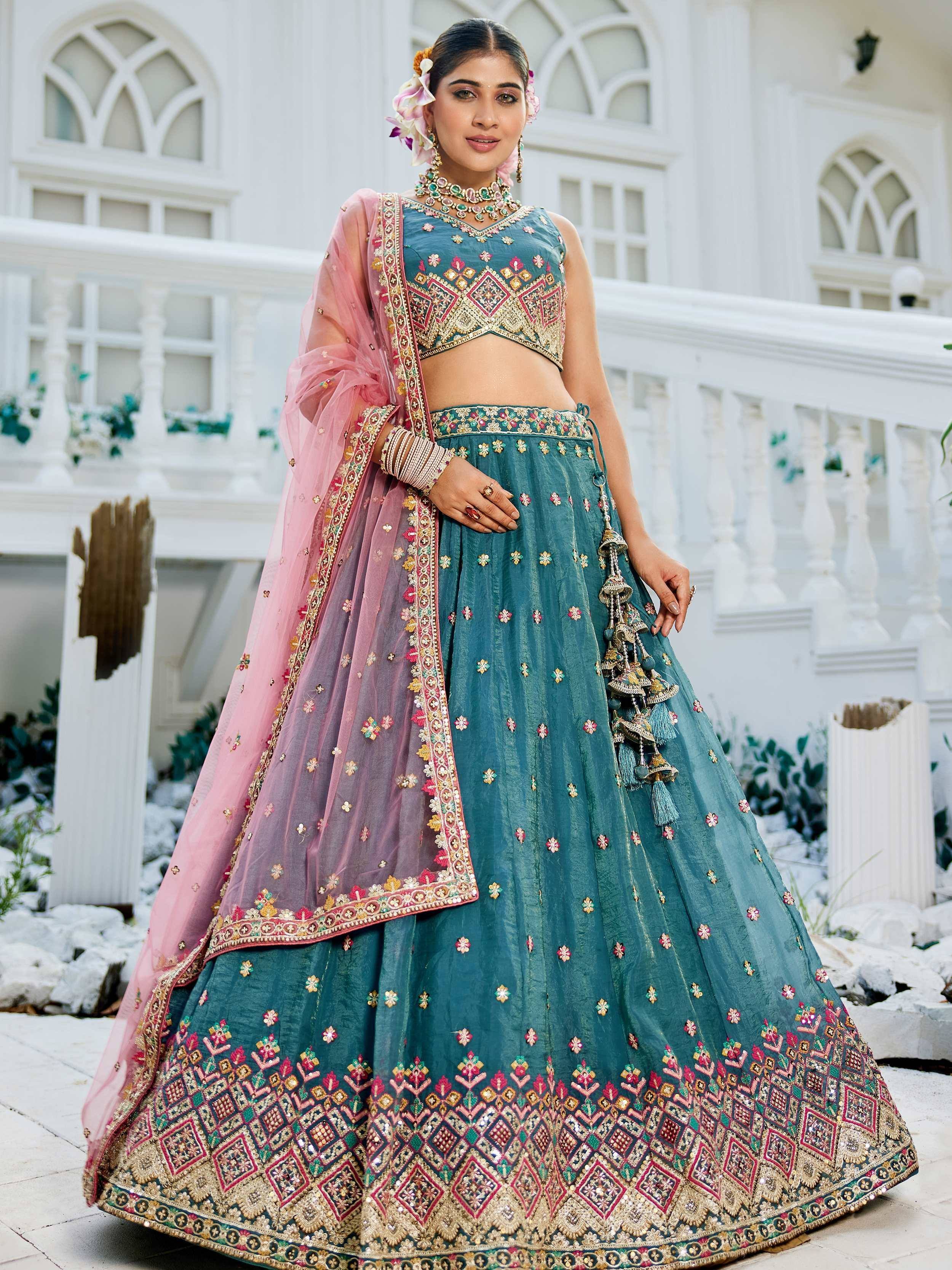 Teal embroidered lehenga choli with pink dupatta, perfect for Indian weddings and festive occasions.