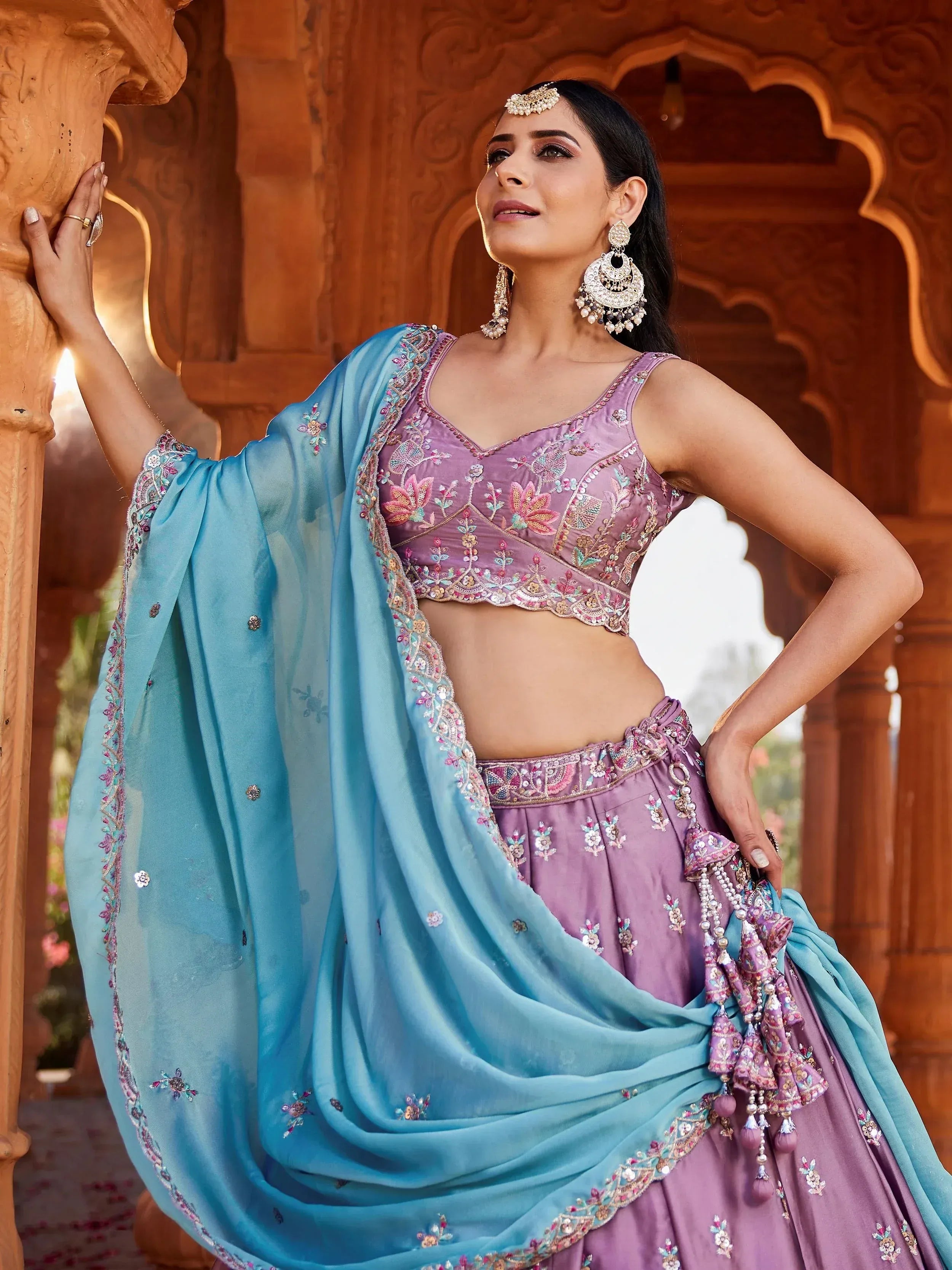 Elegant purple lehenga choli with blue dupatta, floral embroidery, and traditional Indian jewelry