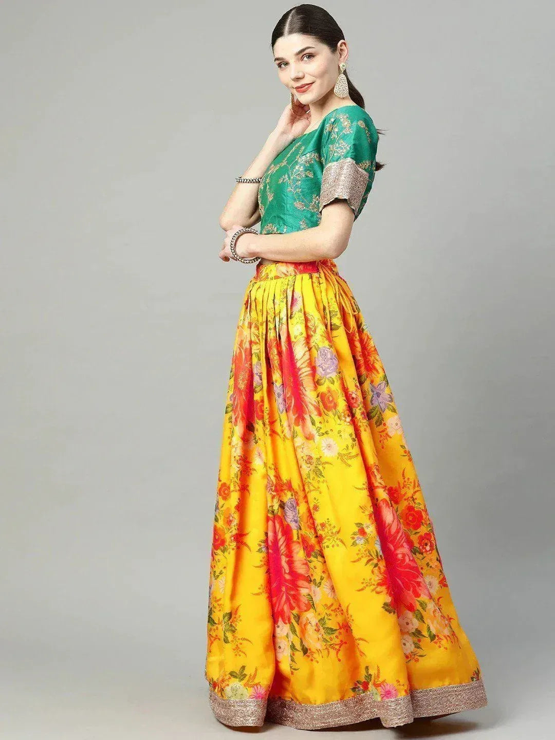 Vibrant yellow floral lehenga with green embroidered blouse, perfect for Indian ethnic wear occasions.