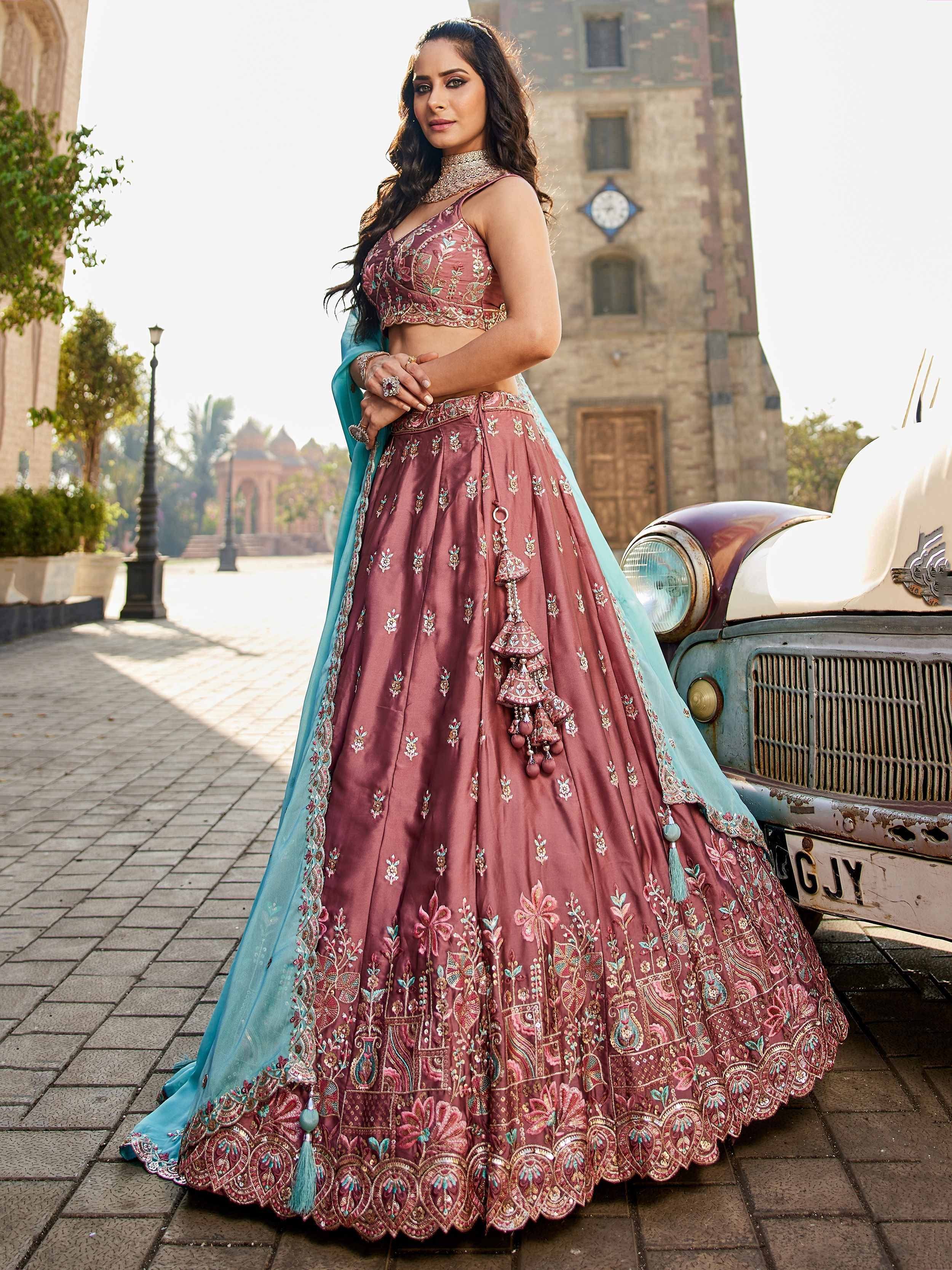 Elegant maroon lehenga choli with turquoise dupatta, intricate embroidery, and tassels, perfect for Indian weddings and festive occasions.