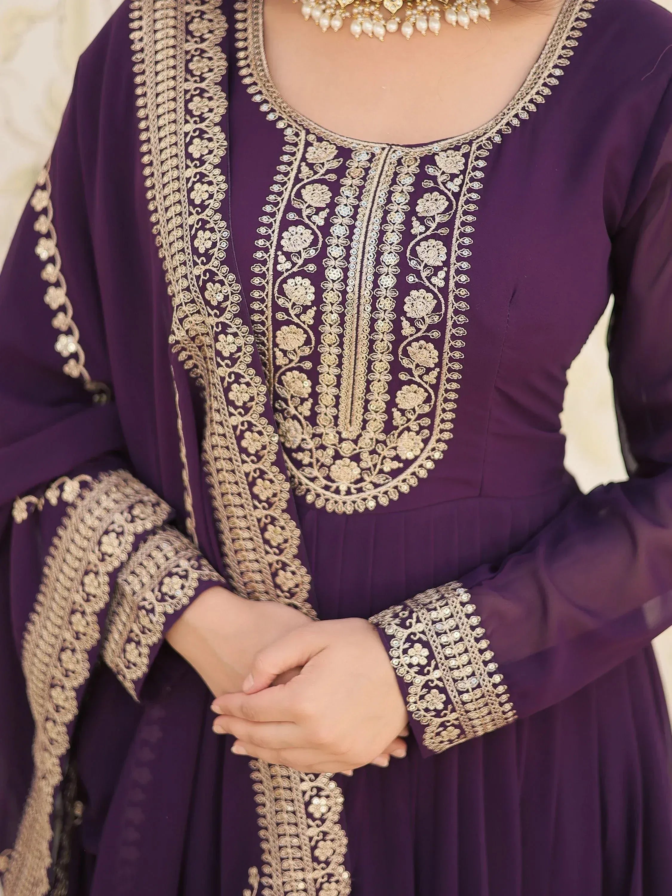 Purple ethnic gown with gold floral embroidery, perfect for Indian weddings or festive occasions.
