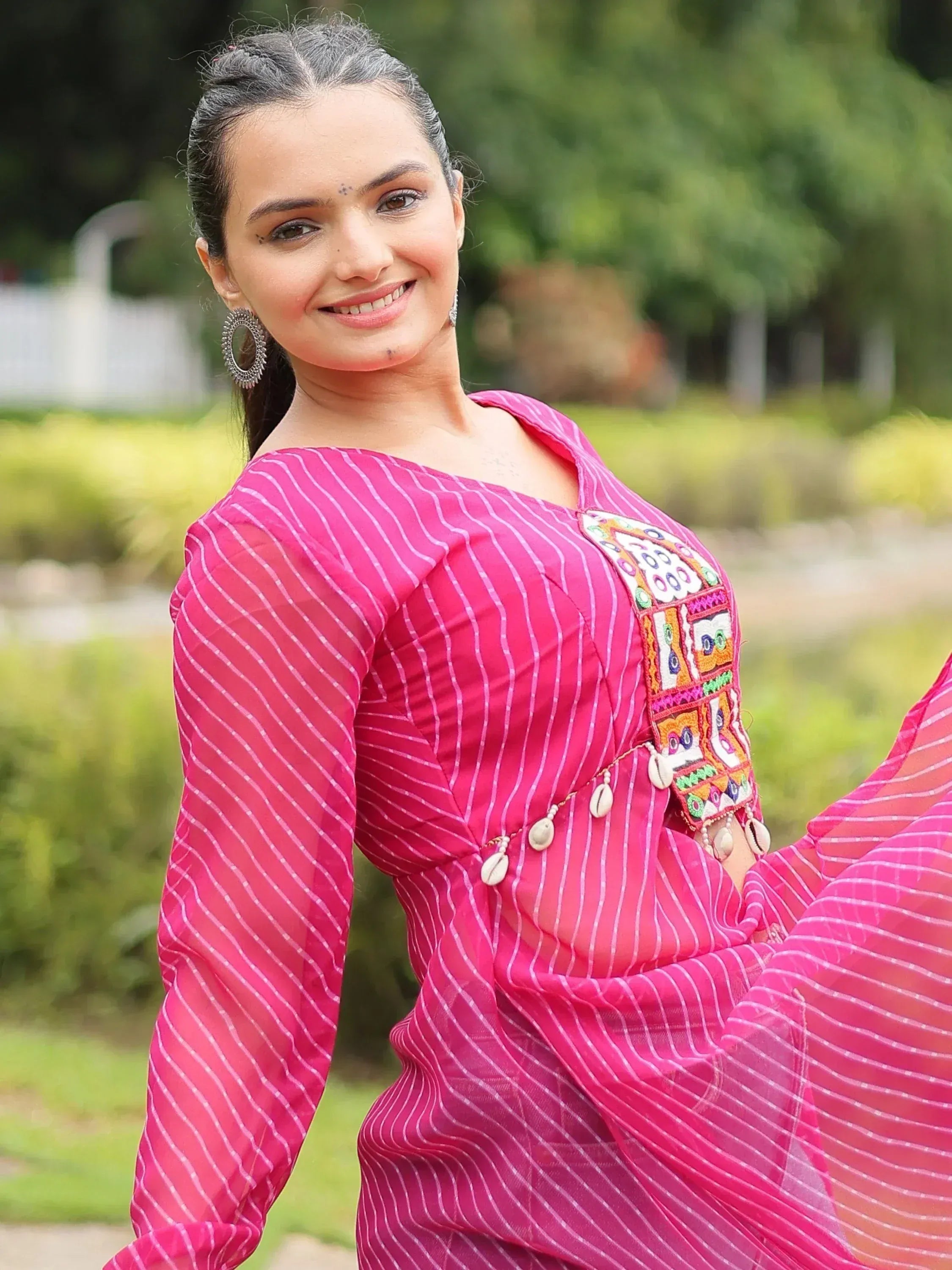 Pink striped ethnic gown with embroidered yoke and shell embellishments, perfect for festive occasions.