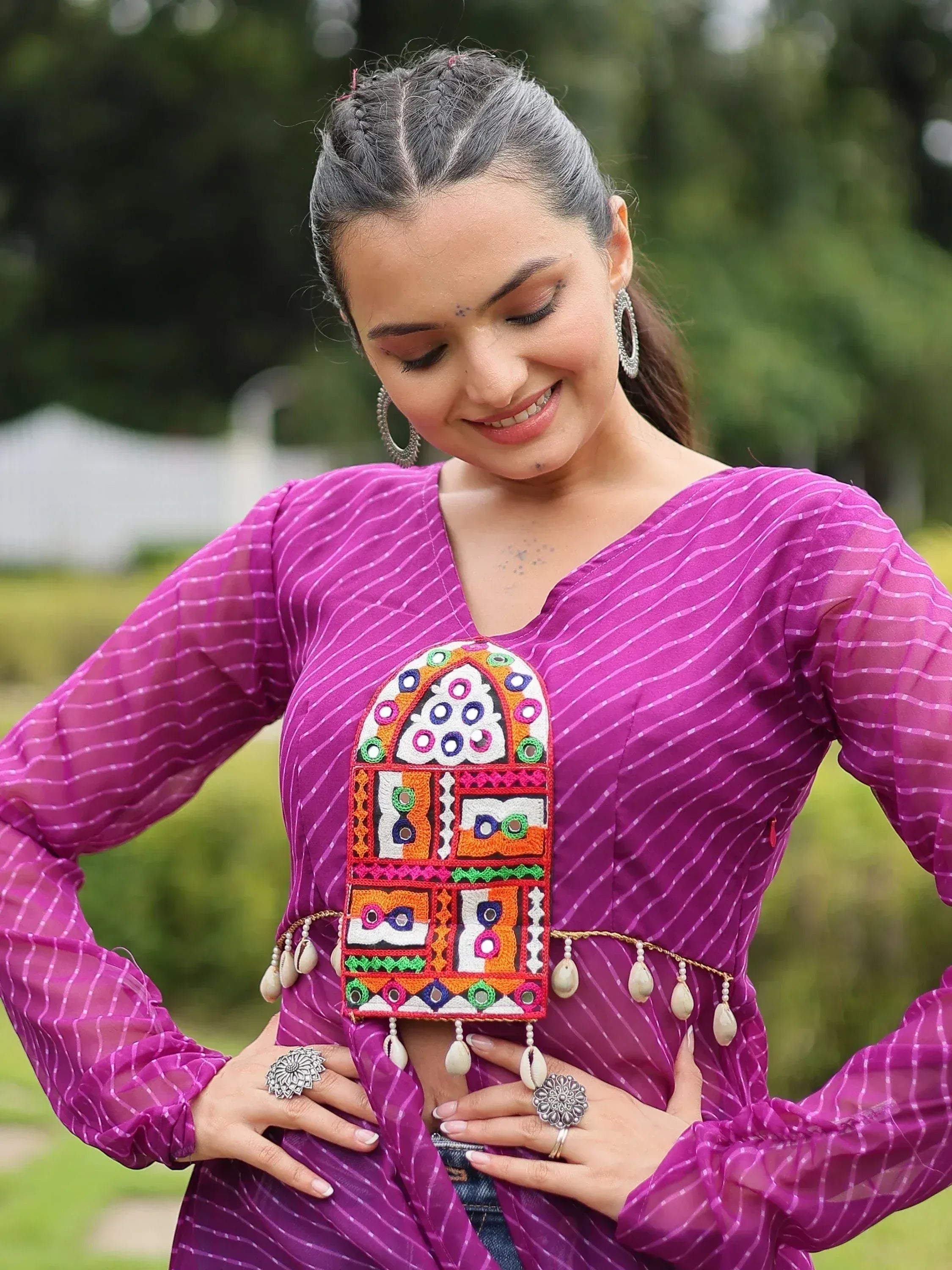 Woman in purple ethnic top with colorful mirror embroidery and shell belt, styled for Indian festive wear