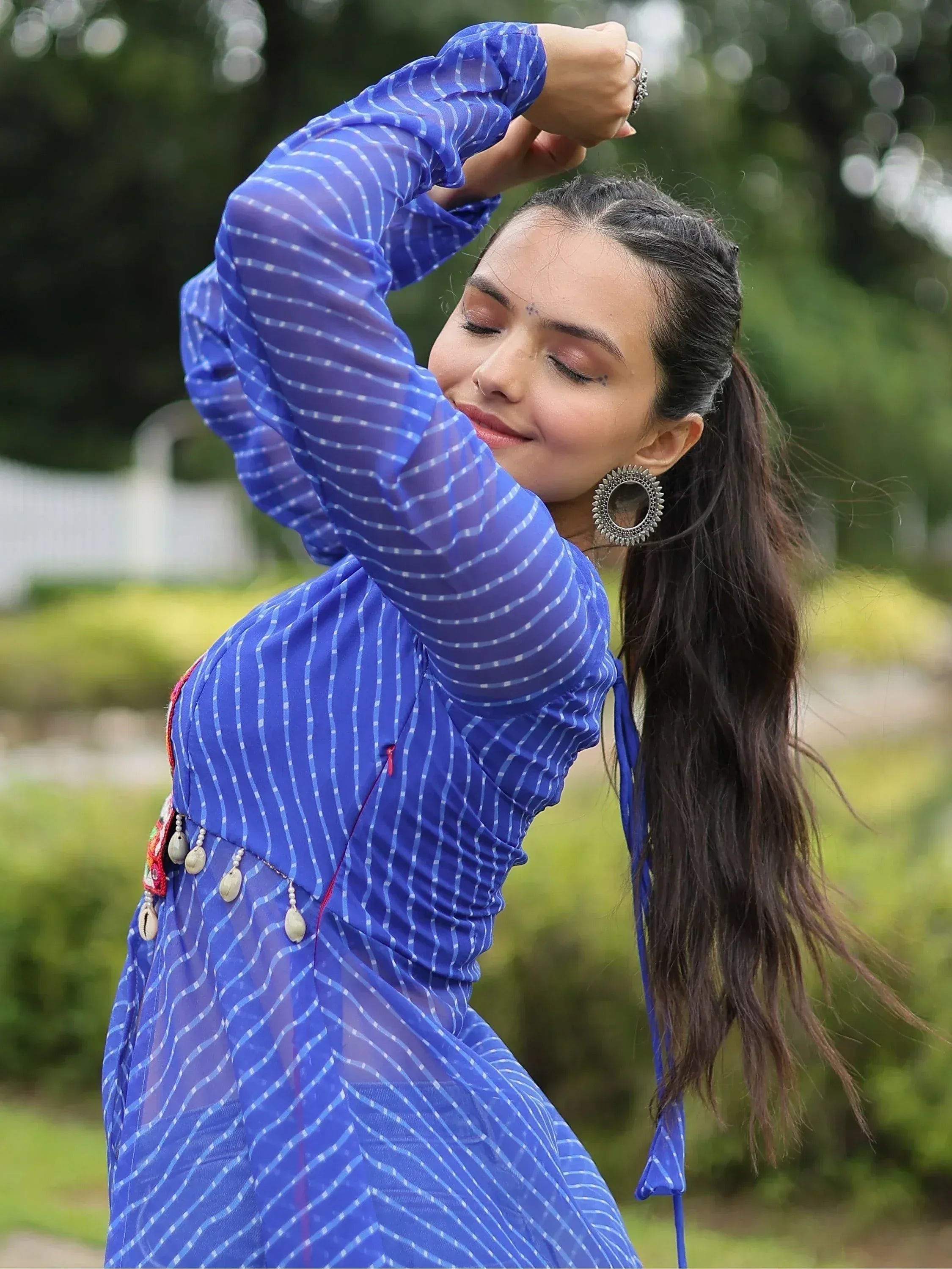 Woman in blue striped ethnic gown with shell embellishments, perfect for Indian festive wear