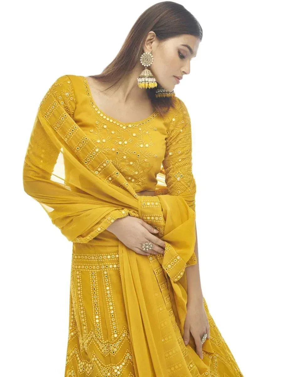 Yellow ethnic lehenga choli with mirror work and dupatta, perfect for Indian weddings and festivals