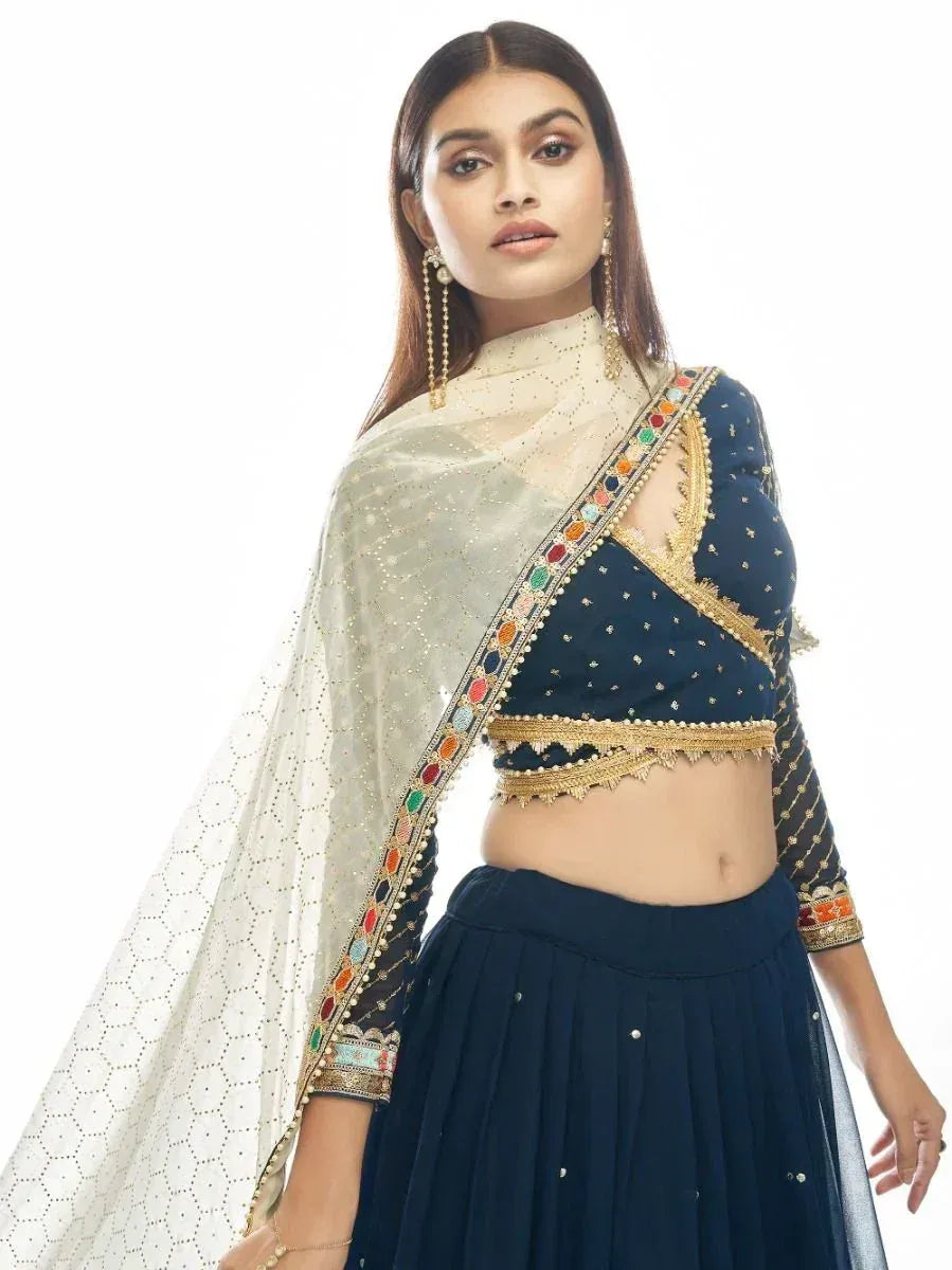 Navy blue designer lehenga choli with gold embroidery and colorful stone work, paired with sheer dupatta