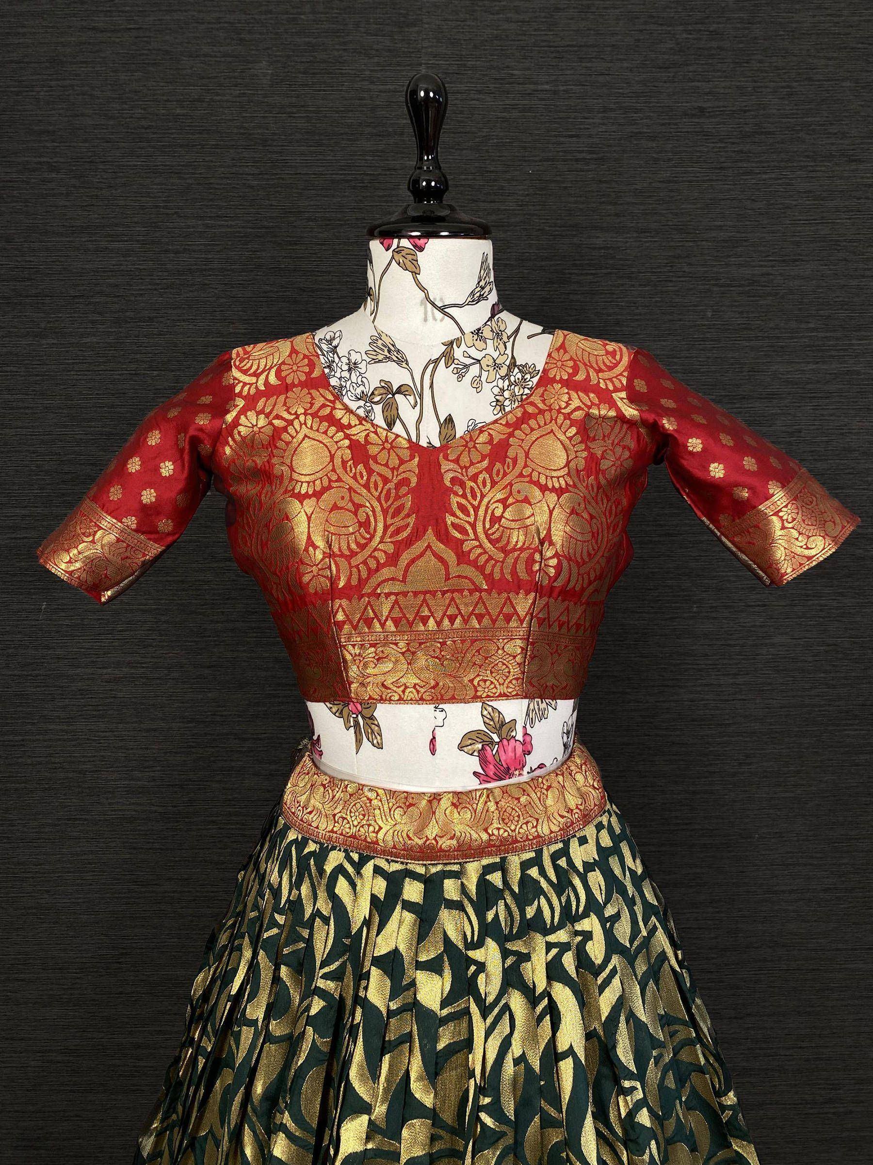 Red and gold designer lehenga choli with intricate floral patterns and pleated skirt, perfect for Indian ethnic wear.