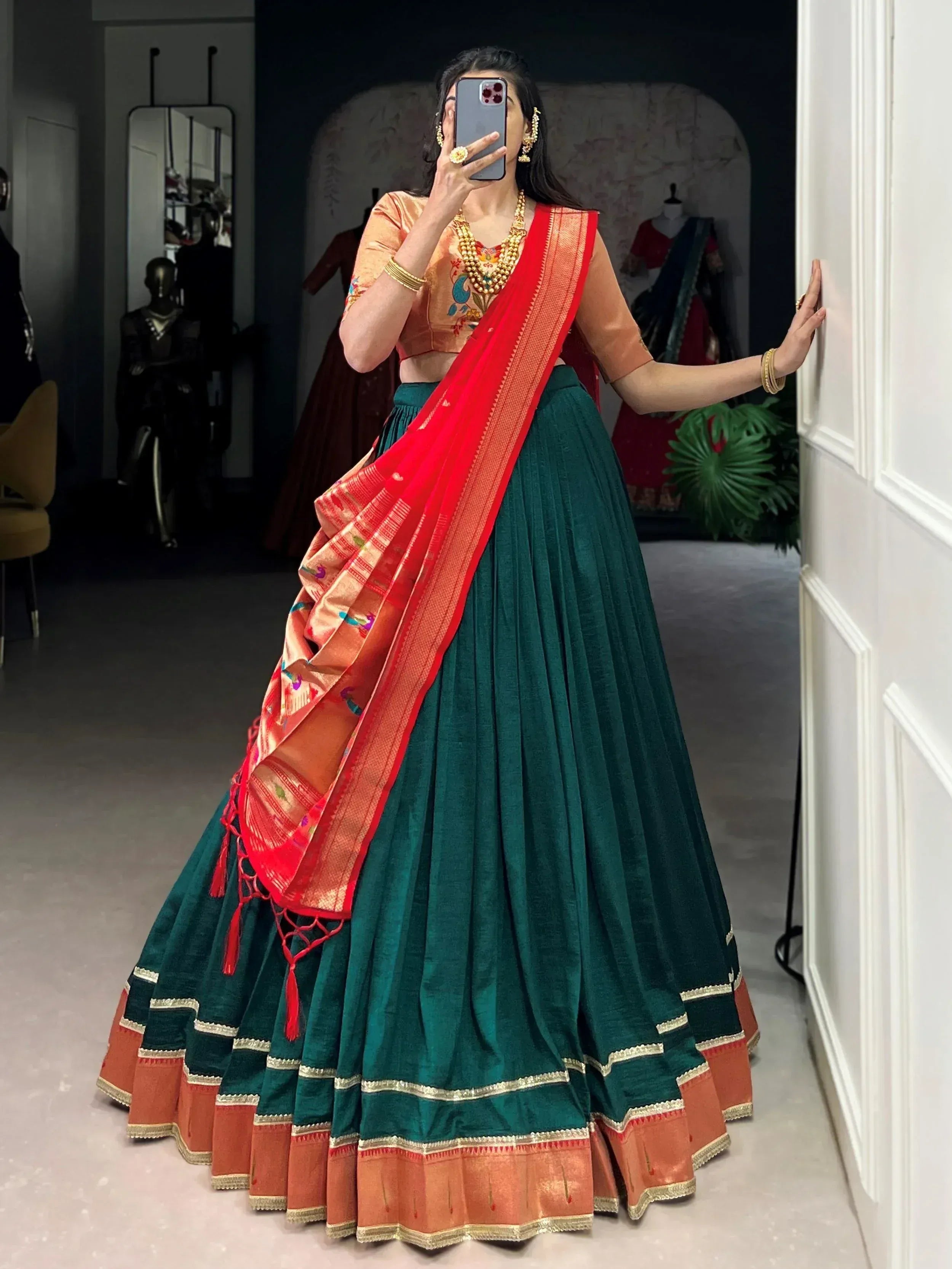 Woman in green velvet lehenga choli with red dupatta, ethnic Indian wear for festive occasions