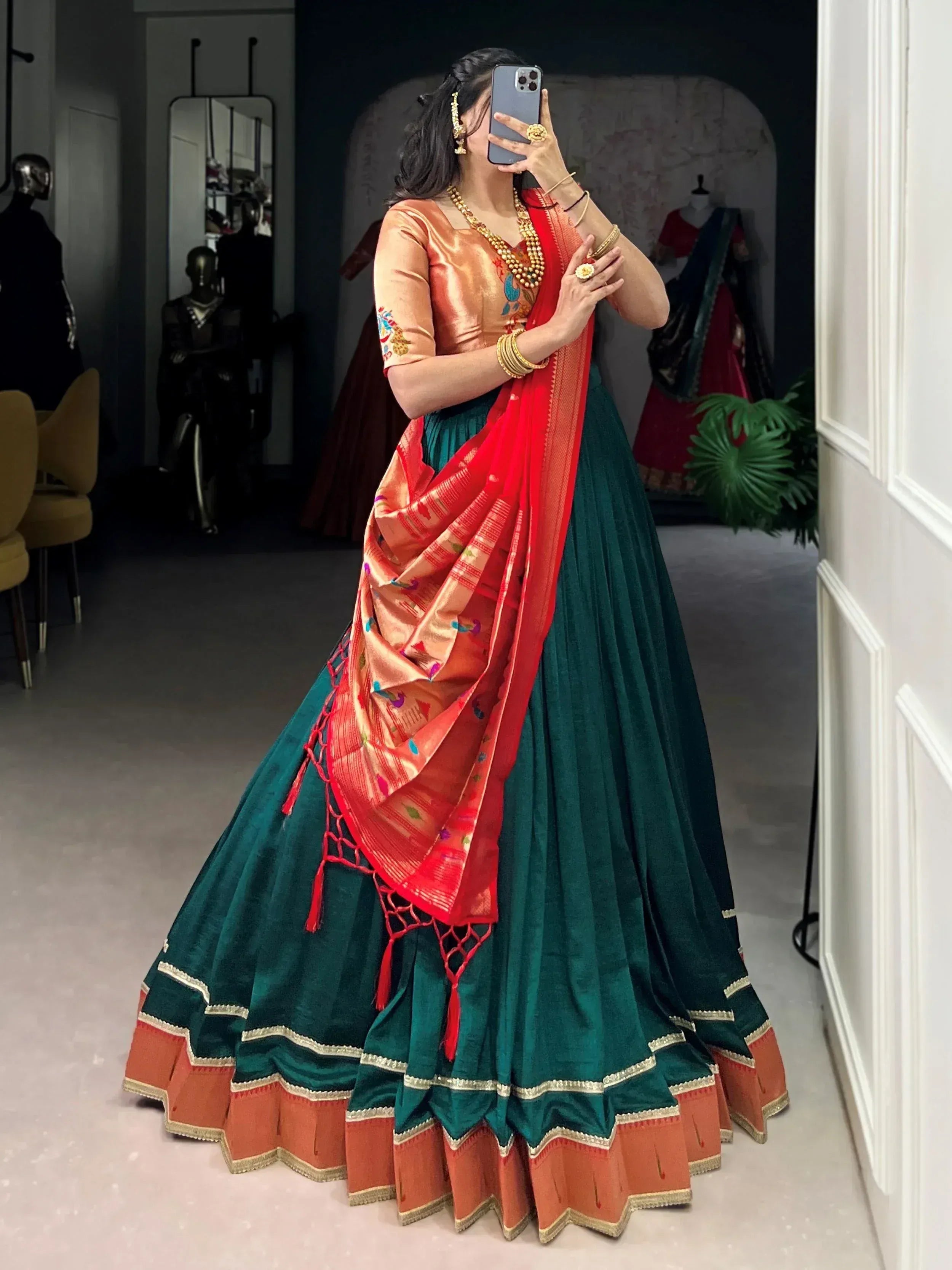 Woman in green velvet lehenga with orange blouse and red dupatta, traditional Indian ethnic wear