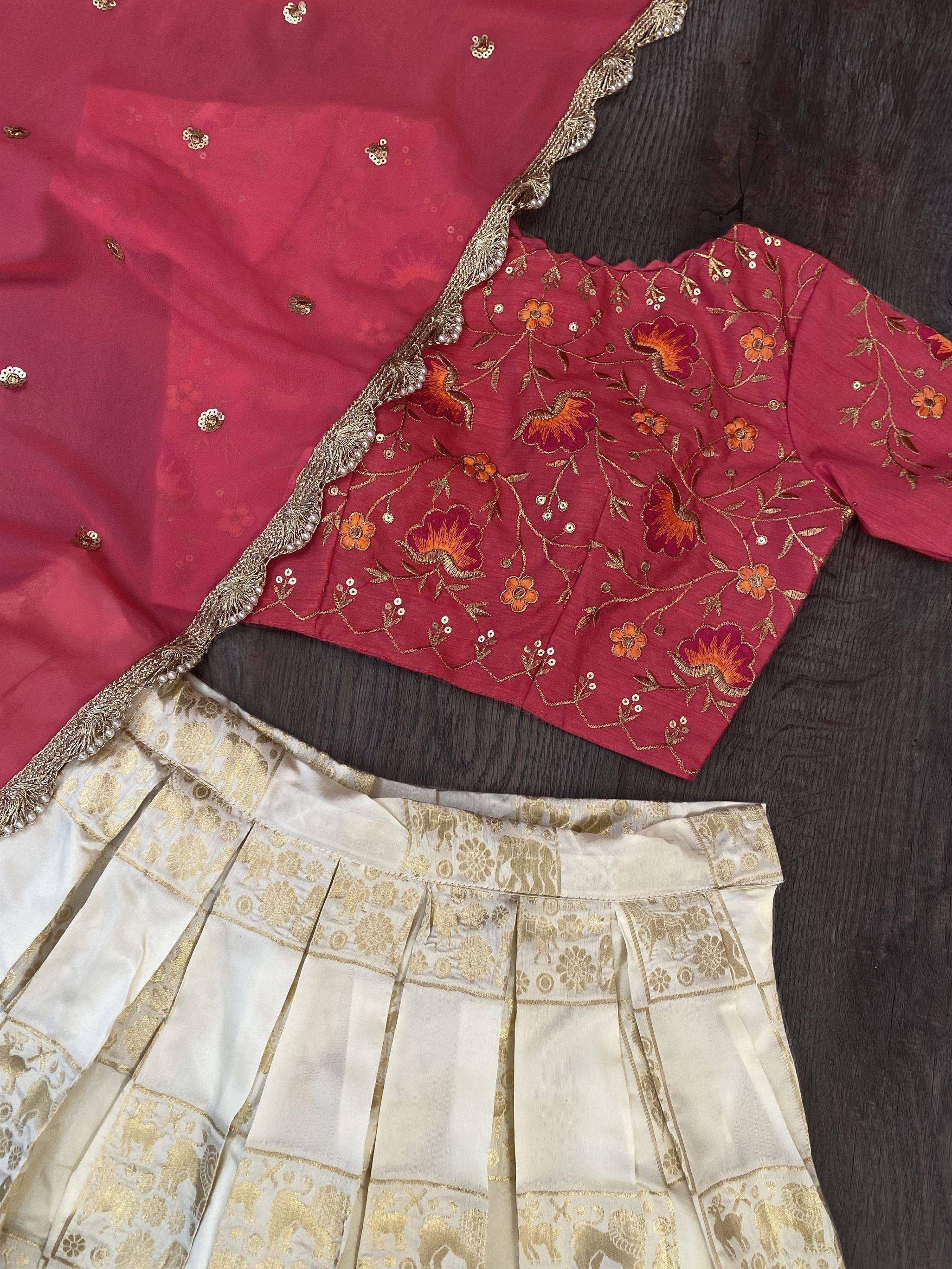 Red floral embroidered blouse with gold detailing, paired with cream pleated skirt and dupatta