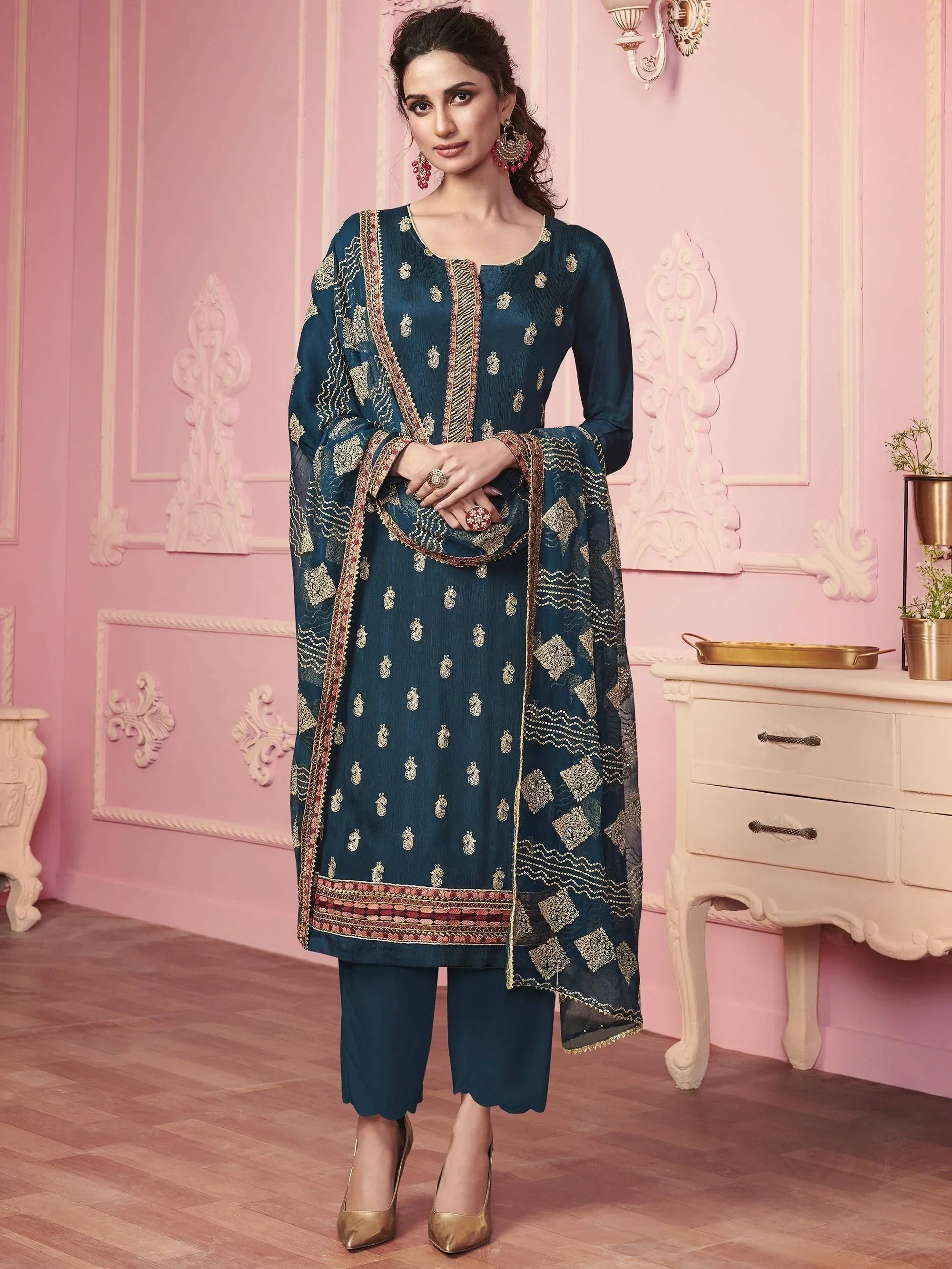 Woman in navy blue embroidered salwar kameez with dupatta, ethnic Indian wear, pink background