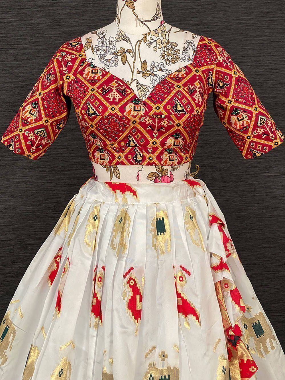 Red and white ethnic lehenga choli with geometric elephant print, floral blouse, and pleated skirt