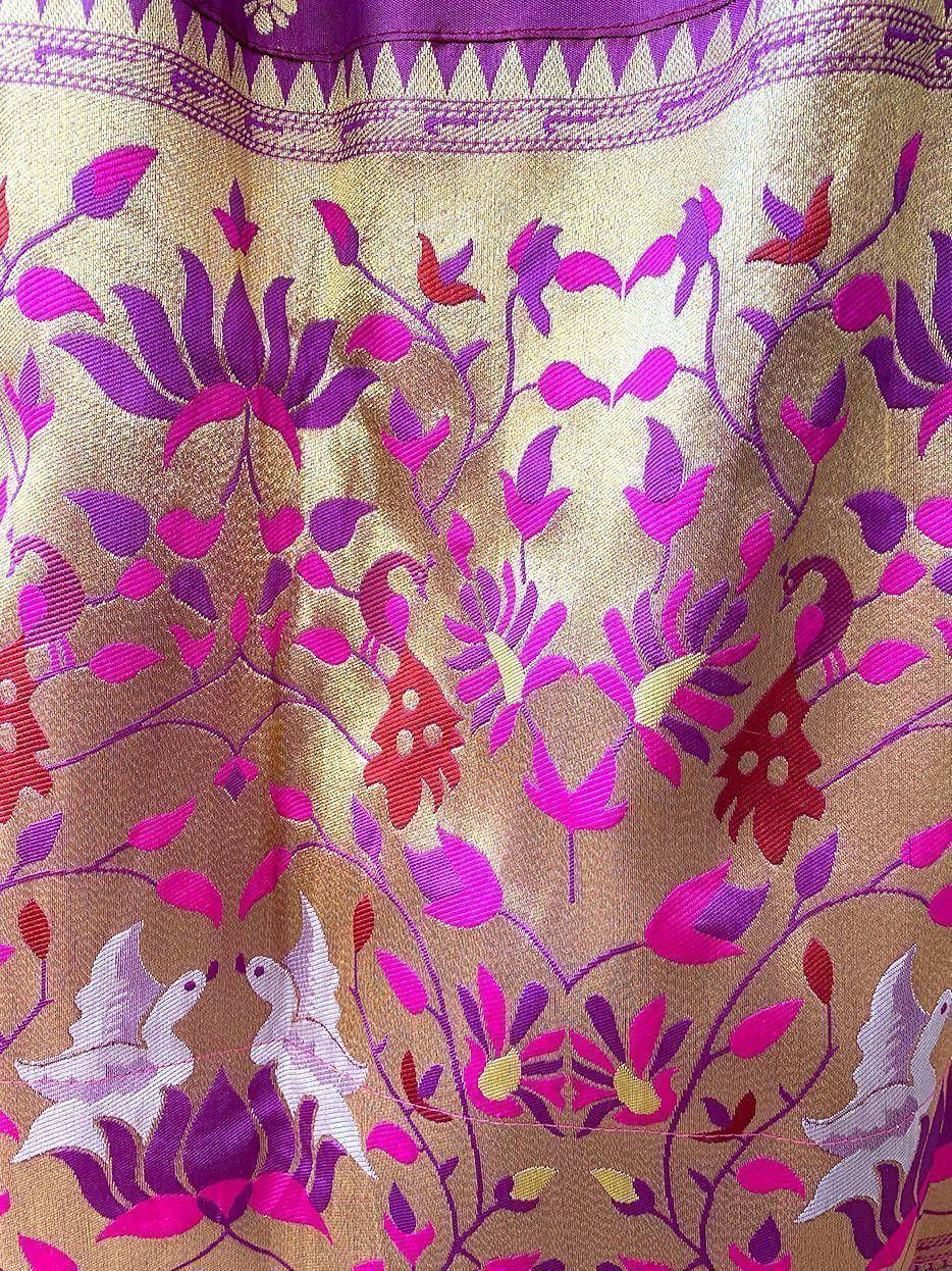 Vibrant purple and gold ethnic fabric with floral and bird motifs, ideal for designer lehenga or saree