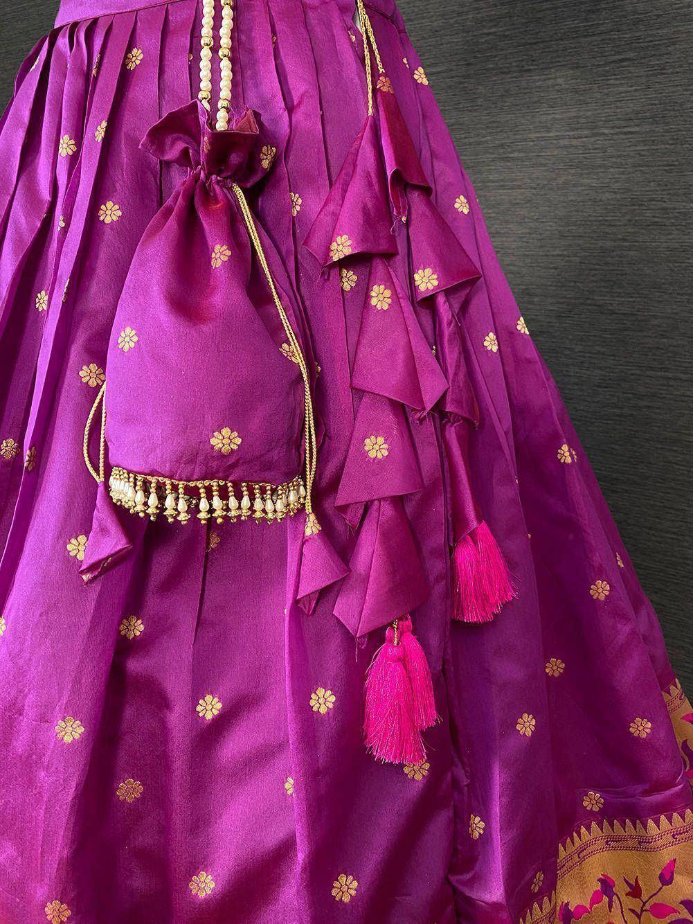 Purple designer lehenga with gold floral embroidery, ruffles, and pink tassels