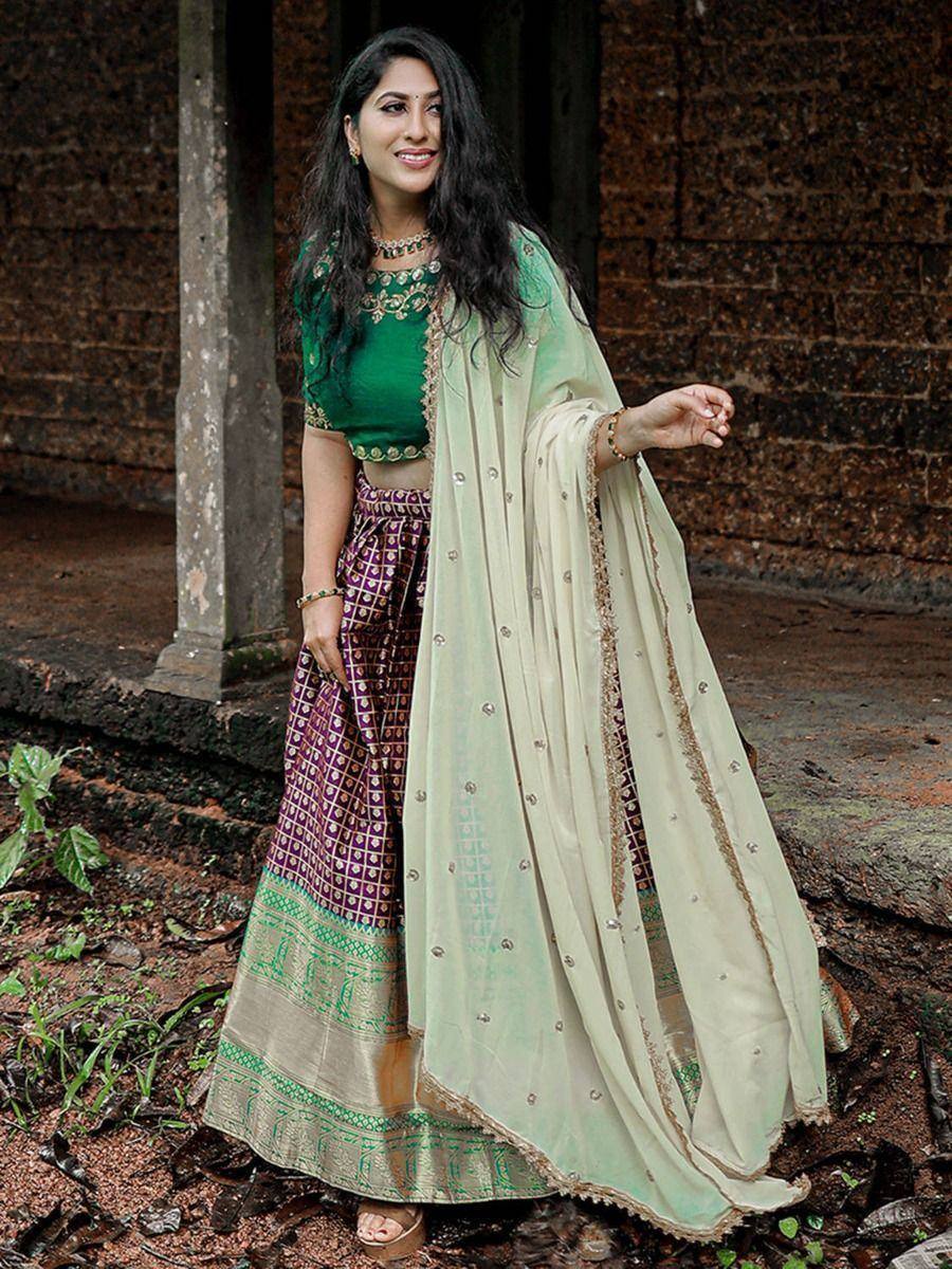 Woman in green embroidered crop top with purple patterned lehenga and sheer mint dupatta, ethnic Indian wear