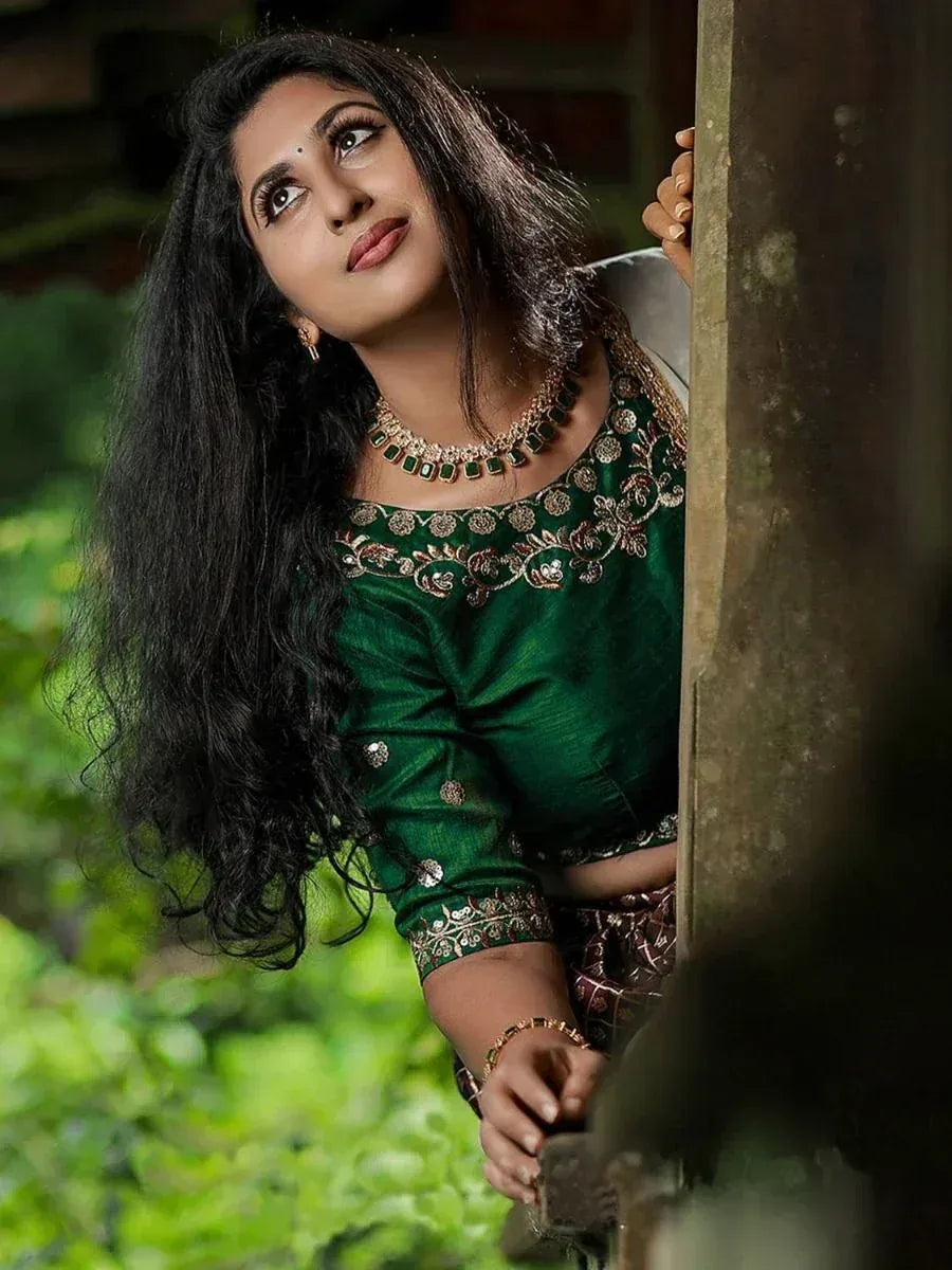 Woman in green embroidered ethnic blouse with gold jewelry, perfect for Indian occasions