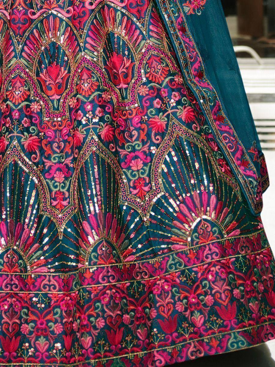 Designer lehenga choli with intricate pink and gold embroidery on teal fabric, perfect for Indian ethnic wear.