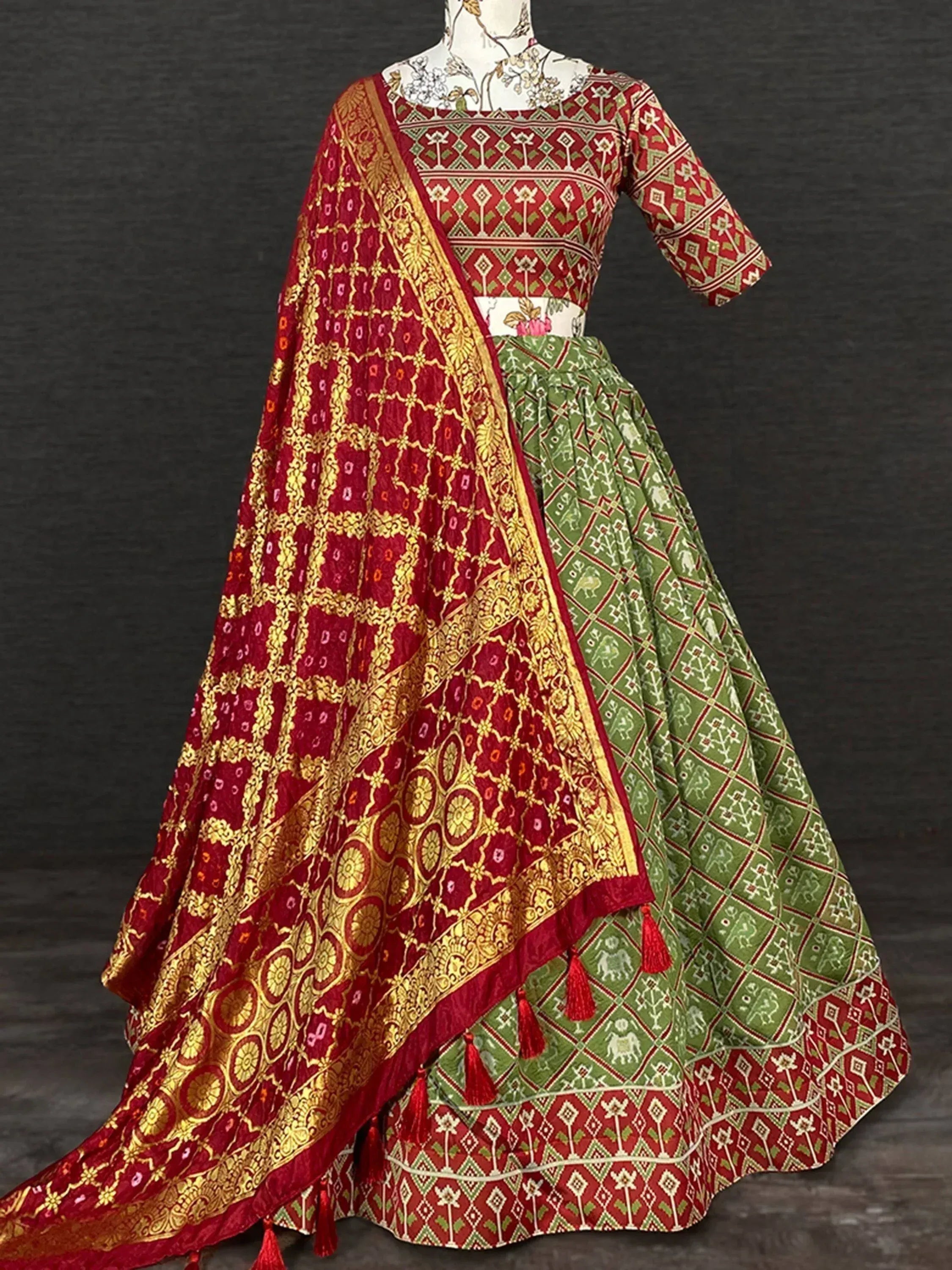 Red and green printed lehenga choli with gold embroidery and matching dupatta, ethnic Indian wear