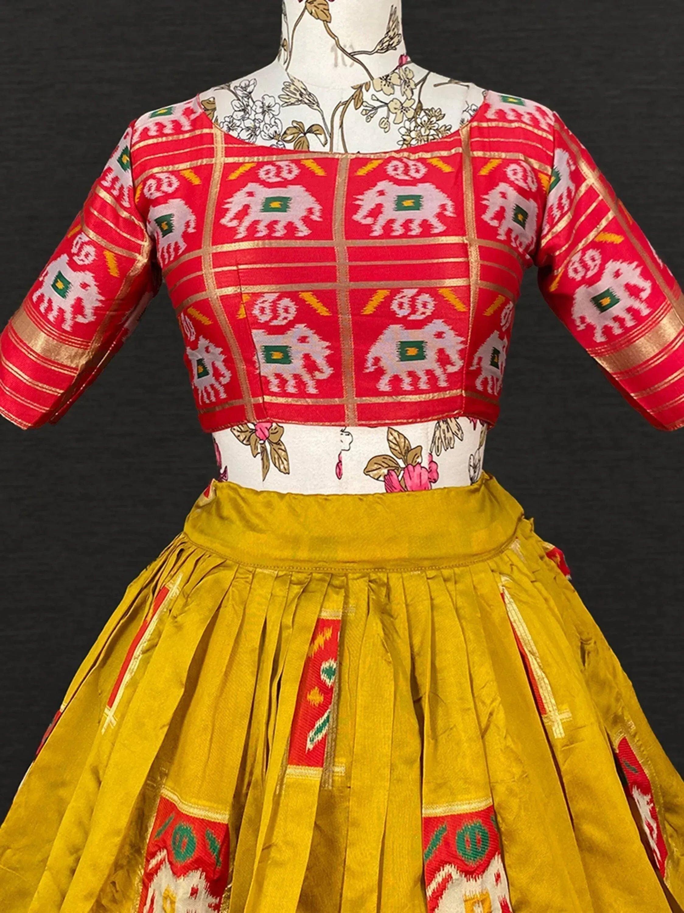 Red and yellow ethnic lehenga choli with elephant print, perfect for Indian festivals and weddings.